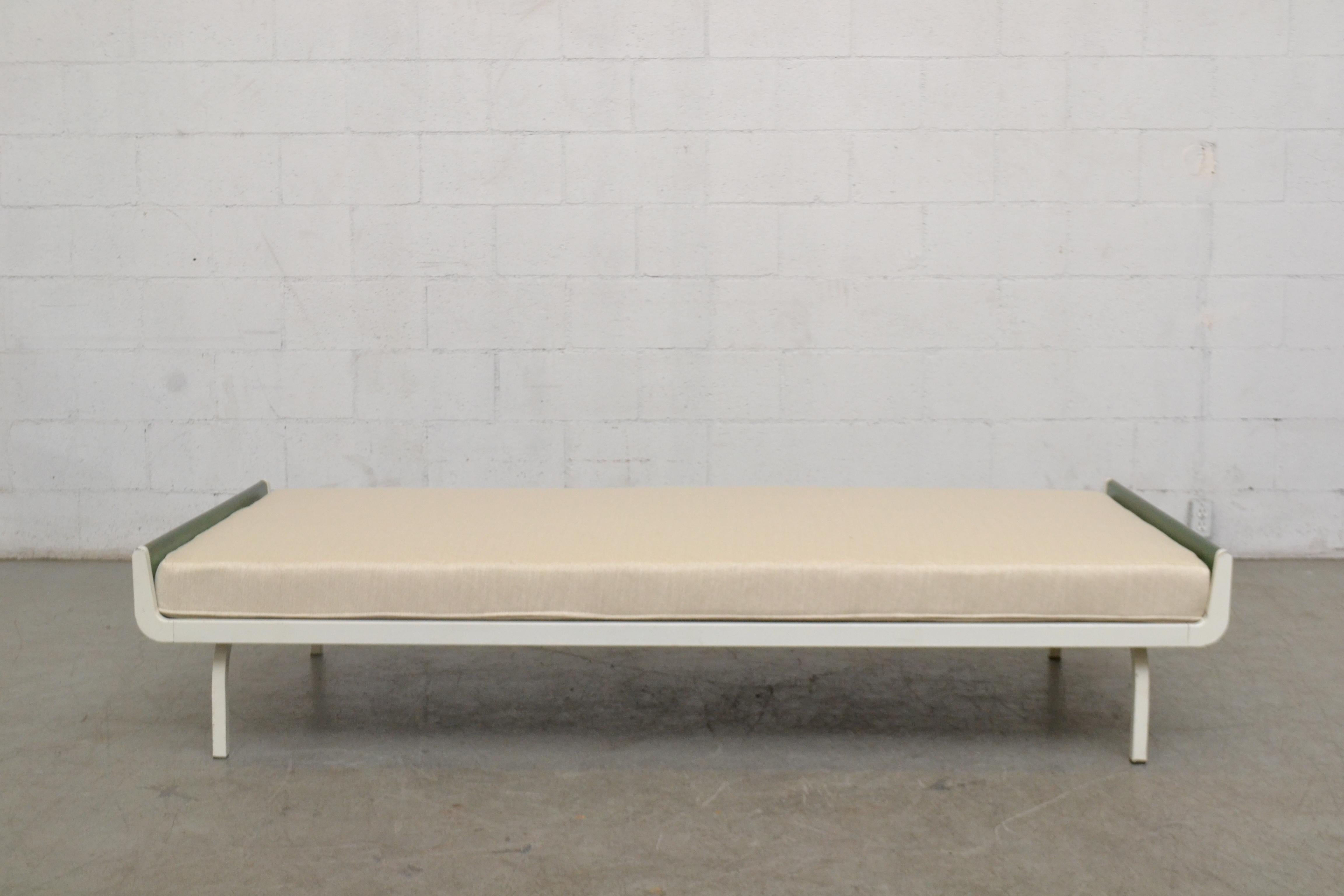 Midcentury daybed designed for Auping in the Netherlands. Green stained wood ends with white enameled metal frame. Newly upholstered cushion in bone white fabric. Frame has visible wear consistent with its age and usage.