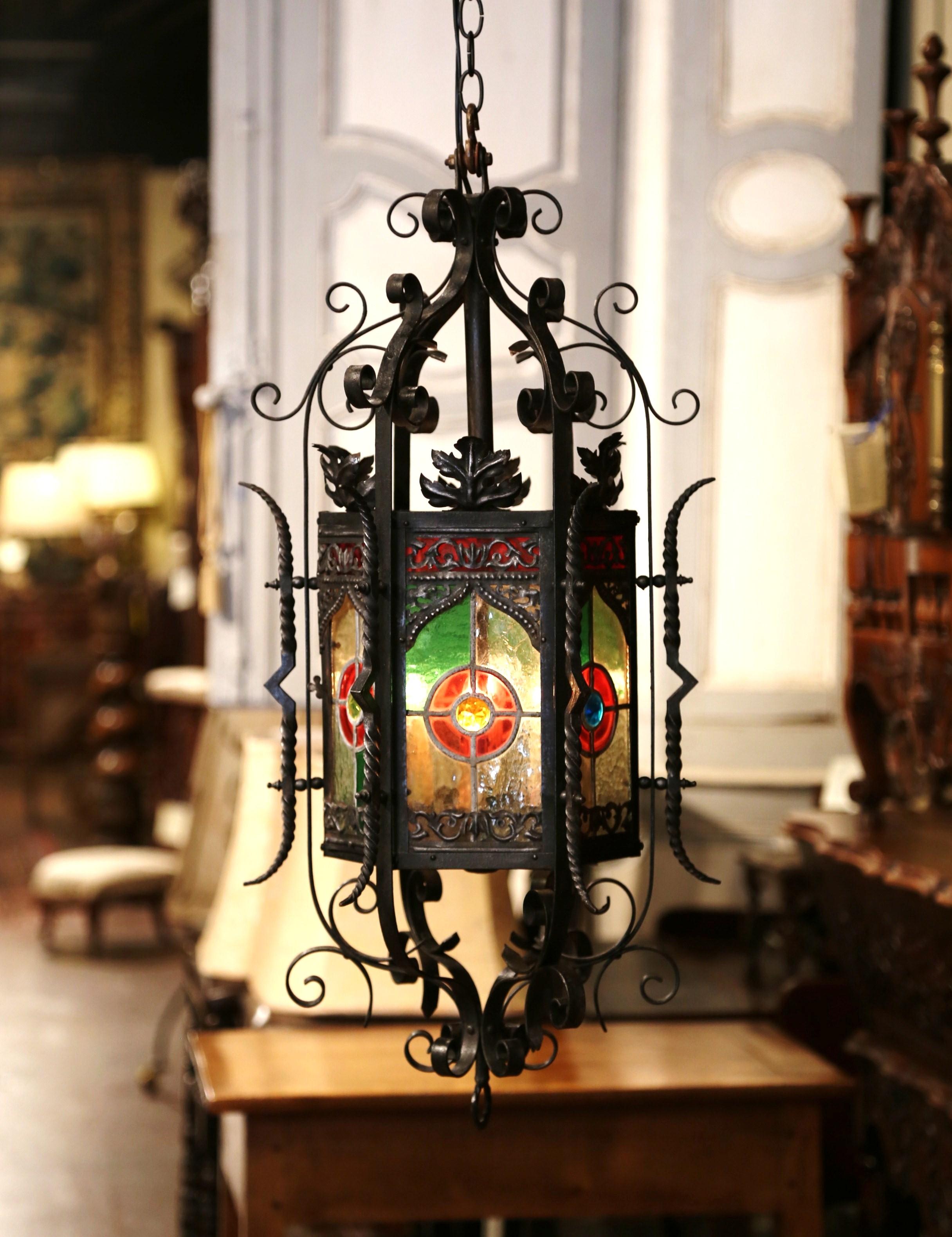 Decorate your entry or powder room with this elegant, Gothic hexagonal lantern. Crafted in France, circa 1870, the fixture has four inside lights, which were newly wired. The antique light fixture has six hand-painted, stained glass panels on each