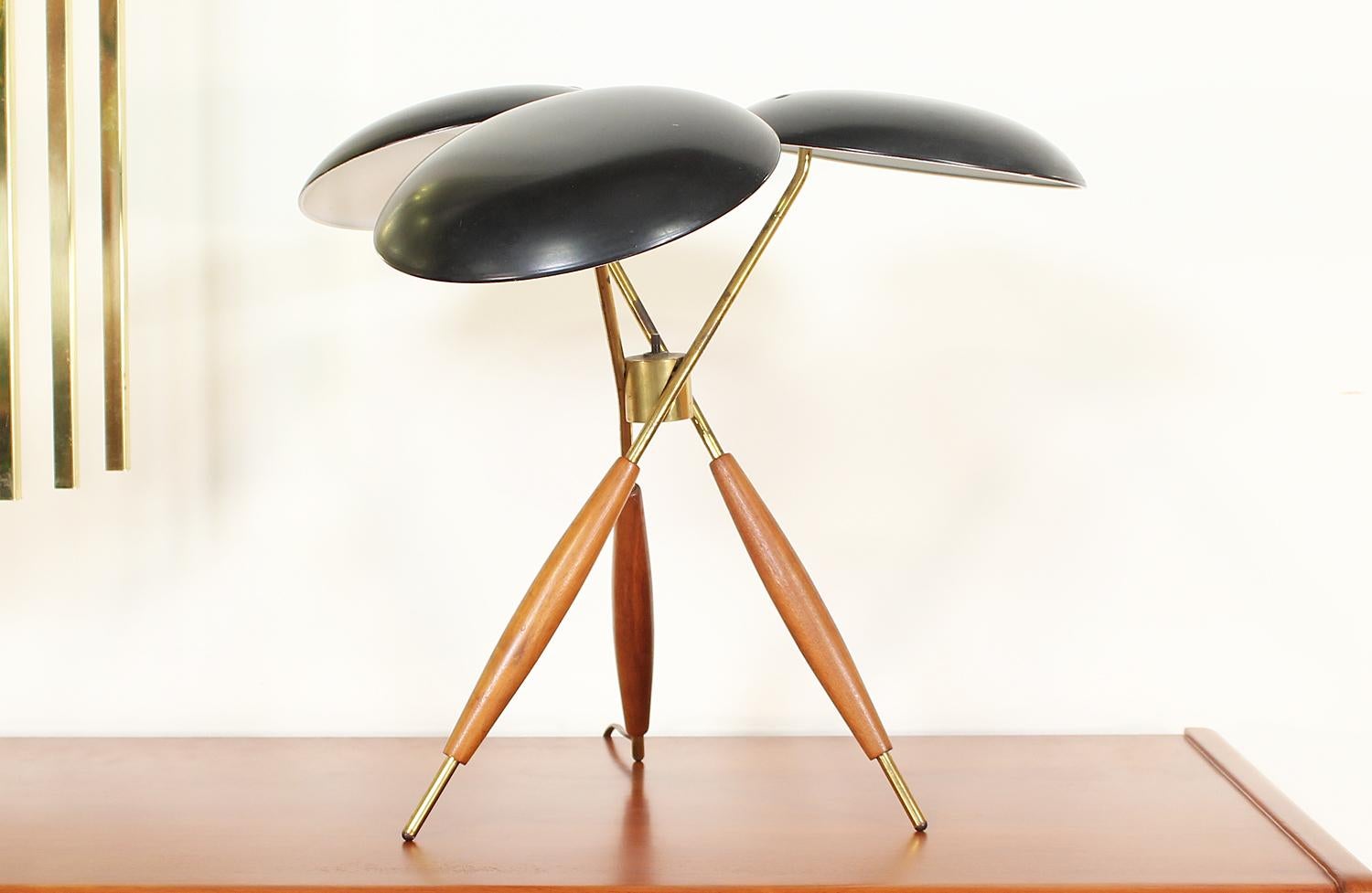 Stunning table lamp designed by Gerald Thurston for Lightolier Co. in the United States, circa 1950s. This stylish lamp features an iconic design with three black lacquered steel shades, creating a unique modern aesthetic, and a distinguished tripod