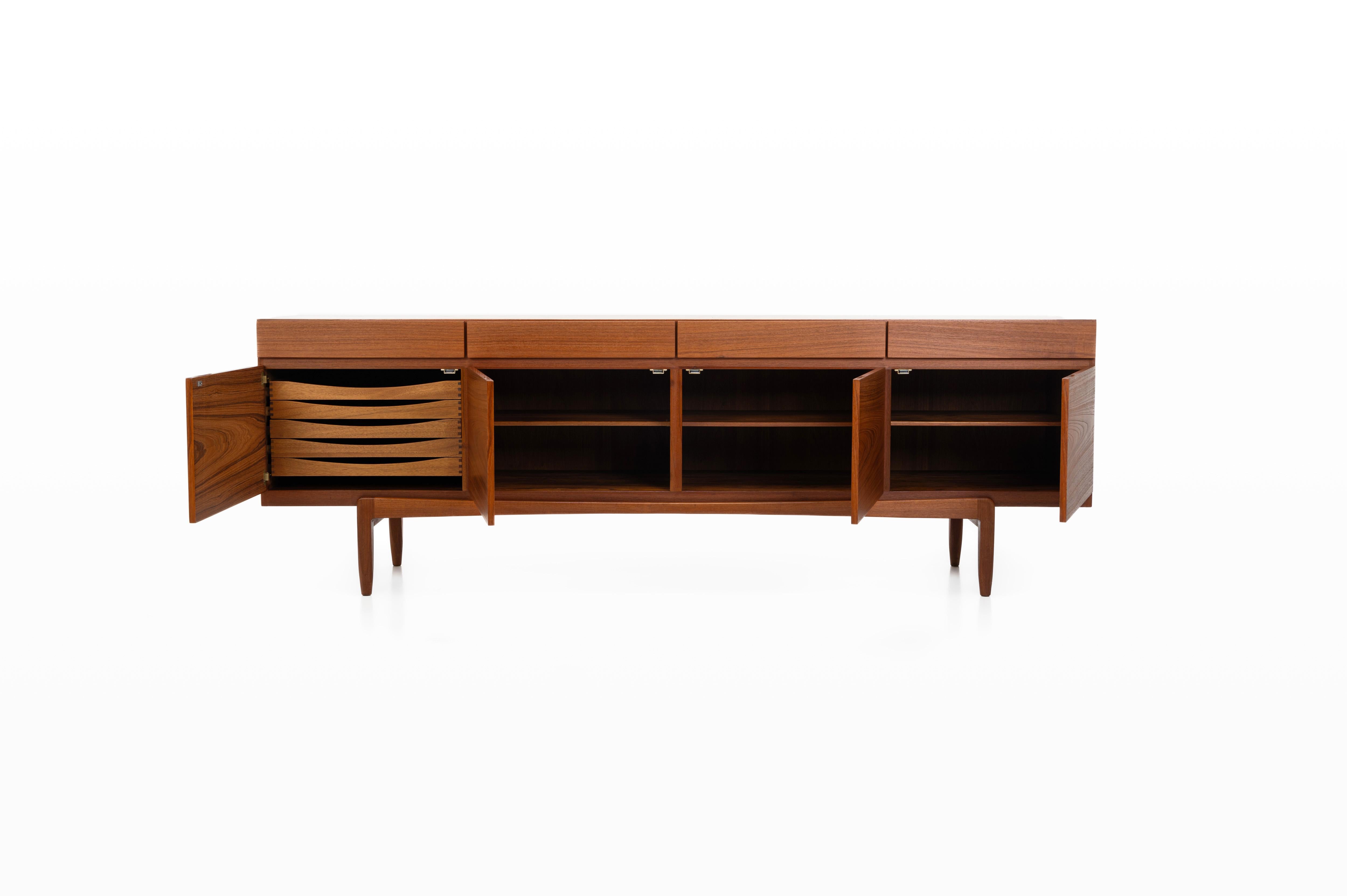 Model 'FA-66’ sideboard in teak, designed by Ib Kofod-Larsen and crafted by Faarup Møbelfabrik in Denmark during the 1960s. Featuring four doors, four drawers, and a lot of storage. This sideboard embodies both functionality and artistry, making it