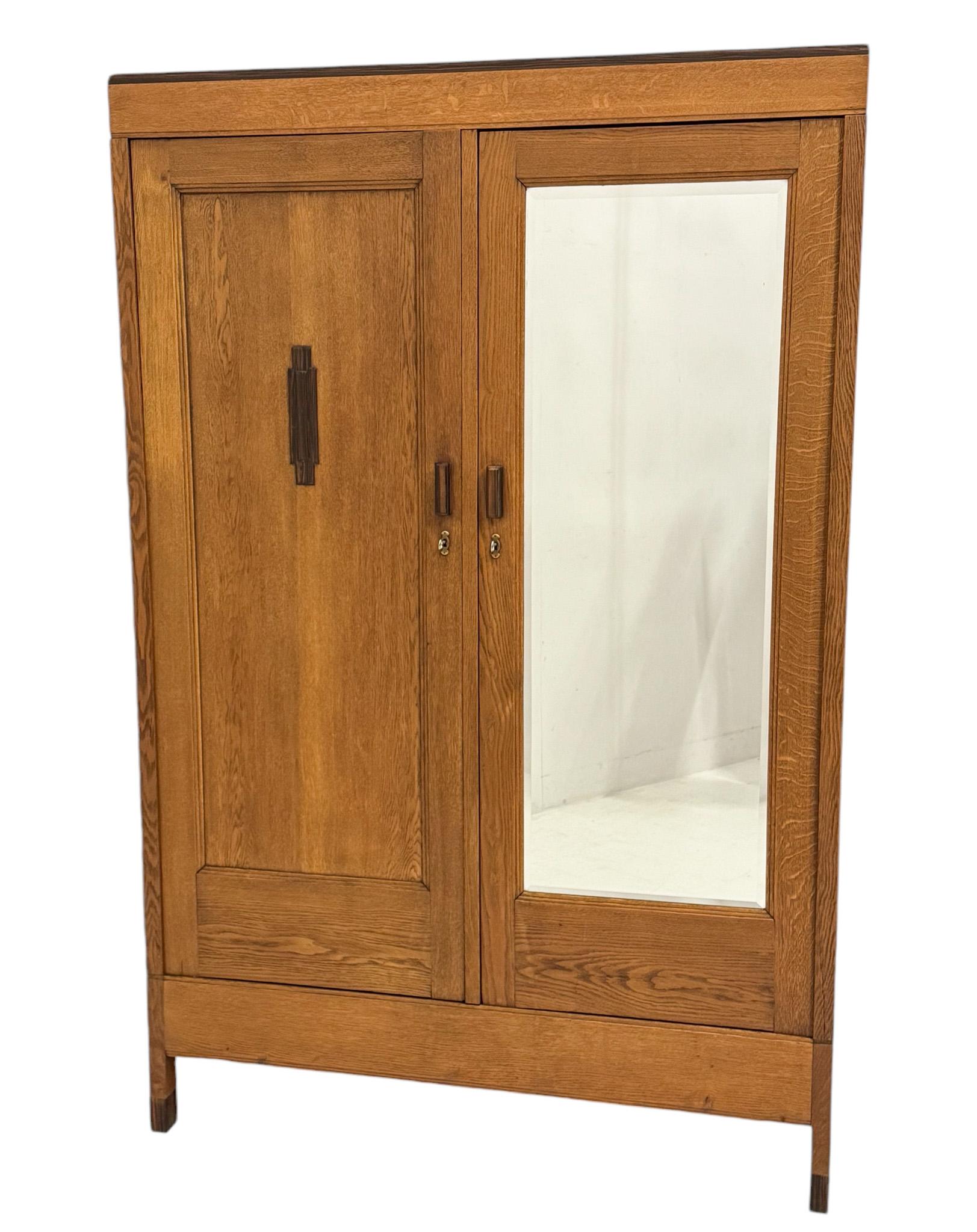 Superbe et rare armoire ou penderie Art Déco de l'école d'Amsterdam.
Design/One. Forage Amsterdam.
Un design néerlandais saisissant des années 1920.
Base en chêne massif avec poignées d'origine en ébène de macassar sur les deux portes.
Derrière la