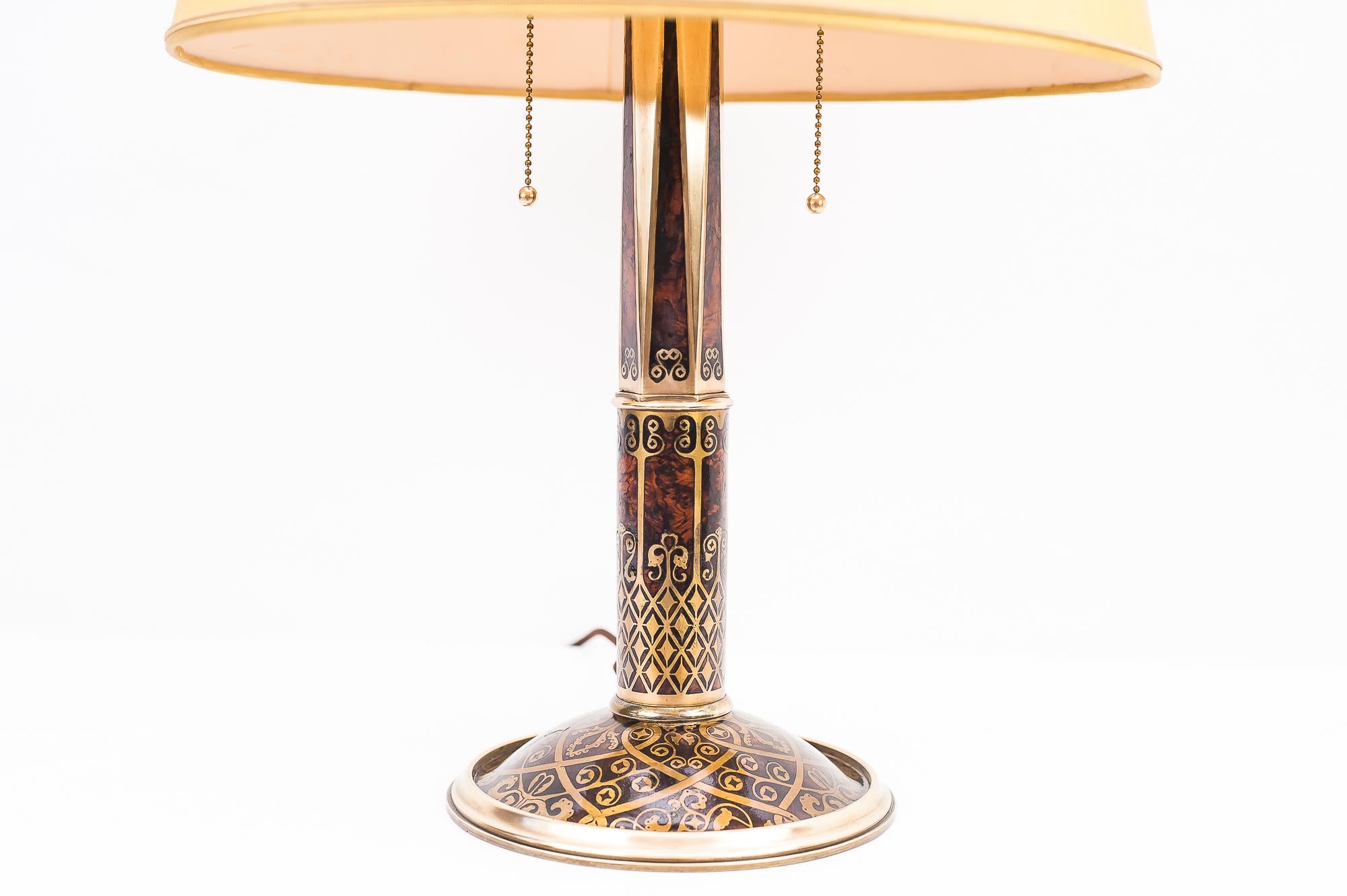 Fa. Erhard & Söhne, Schwäbisch Gmünd, circa 1920, brass with root wood inlays,
The fabric shade is not in a perfect condition, but it is original.

Original condition.