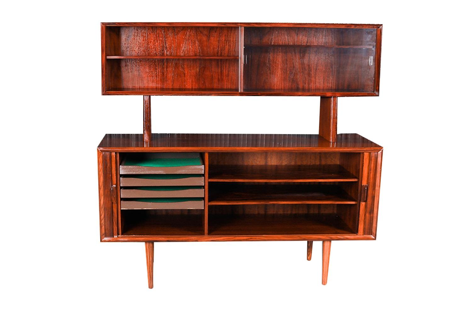 Remarkable, rare, rosewood, stunning two-piece Petite hutch credenza by Famous designer Svend Larsen for Faarup Mobelfabrik, made in Denmark. This Danish Modern Rosewood credenza / Media China Cabinet is beautifully embellished with bands of