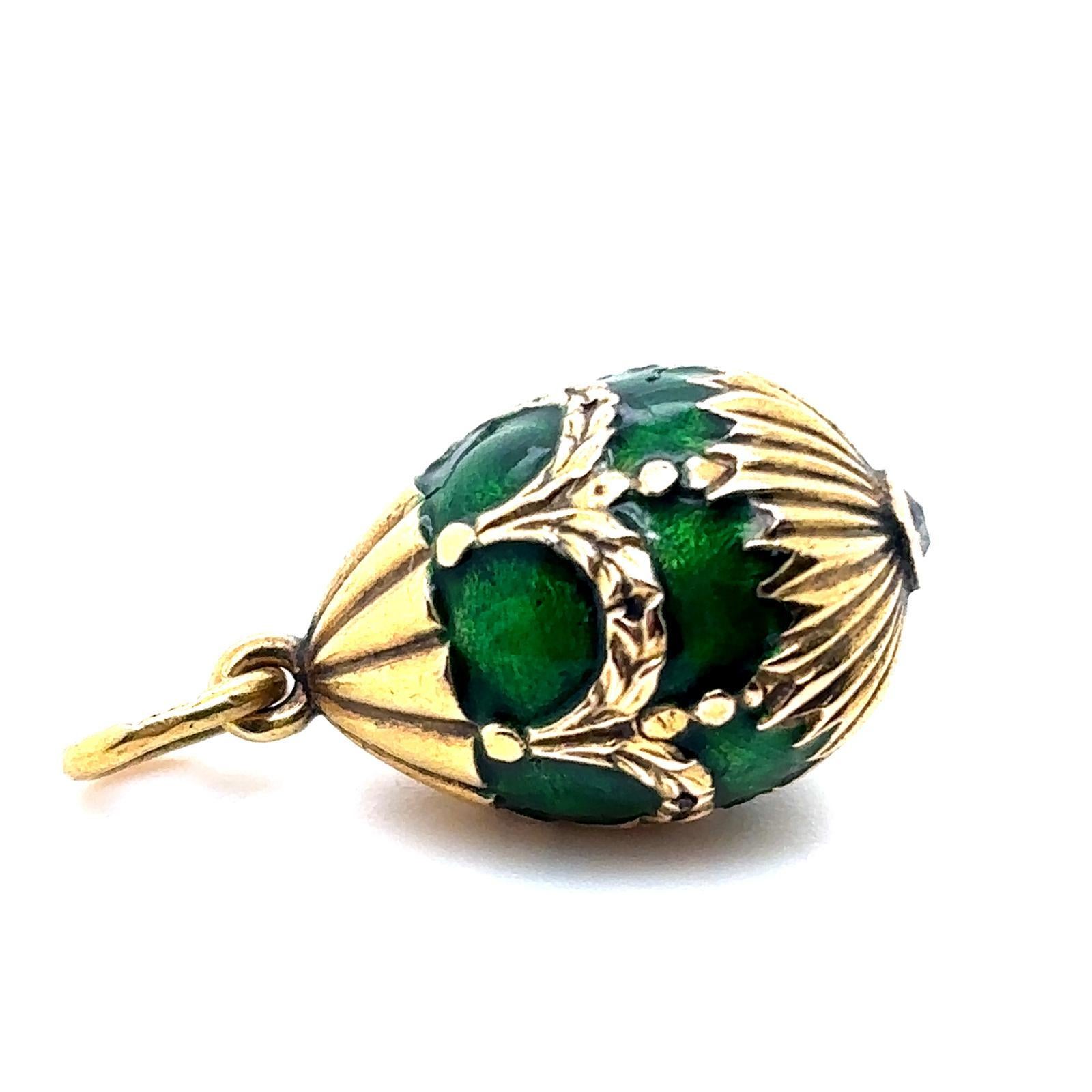 A Fabergé 18 karat yellow gold green enamel diamond egg pendant 

Designed as an 18 karat yellow gold egg with Fabergé's signature green guilloché enamel featuring yellow gold relief depicting swags and festoons all the way around the pendant and