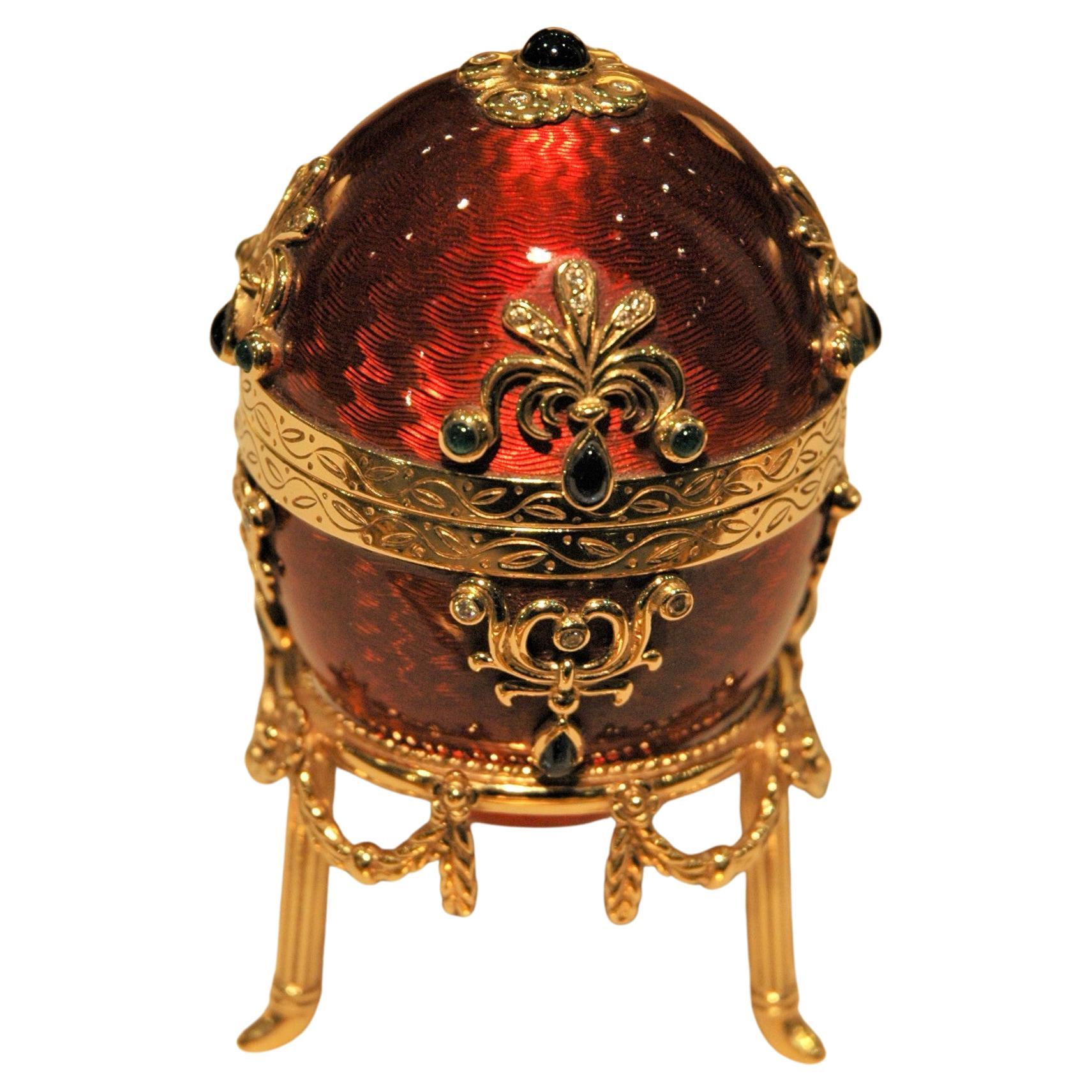 Fabergé 18 Kt Gold Egg Red Enamel with Gold Stand, Emeralds, Sapphires, Diamonds (Oeuf en or 18 Kt émaillé rouge avec Stand en or, émeraudes, saphirs, diamants) en vente