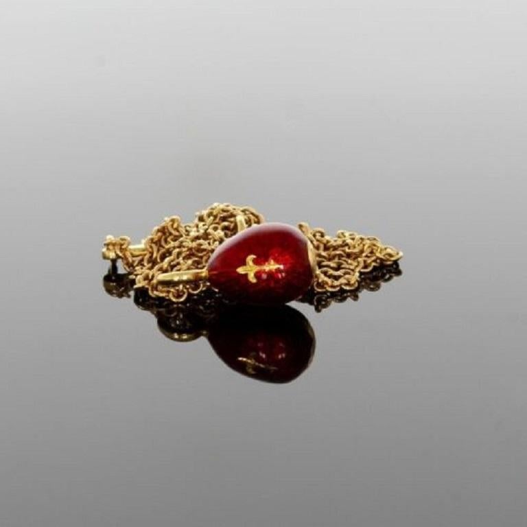 18ct yellow gold Faberge egg pendant 10.0 x 7.4mm.  The egg is in deep red guilloche enamel with a gold Fleur de Lis to the front.  The Faberge trace link chain is 17