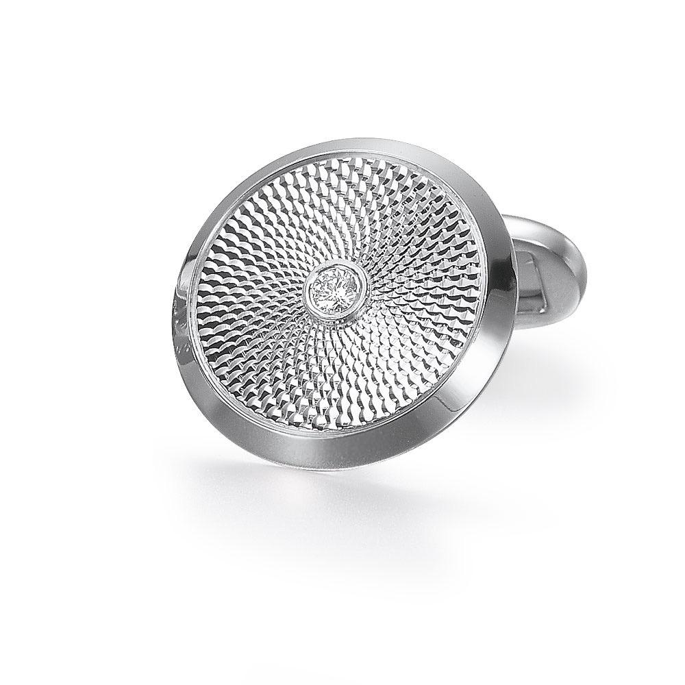 These classic Faberge 18 karat white gold cuff links are designed with engine turned engraving. Each cuff link has a round brilliant diamond center in a bezel setting. 
Total diamond weight 0.14cts. Limited edition #16/500
The diameter is 20