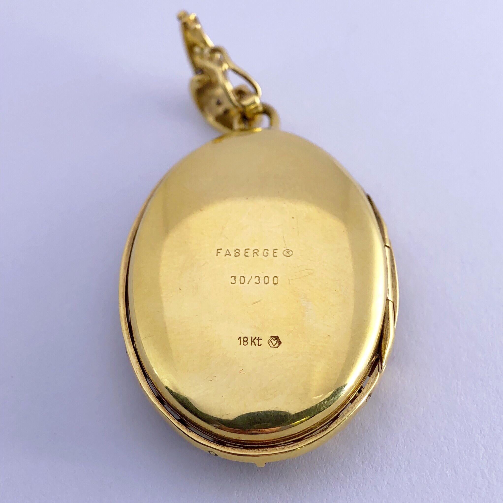 This Modern Faberge 18 Karat Yellow Gold and Blue Caged Guilloché locket opens and can hold two photographs measuring approixmately 1