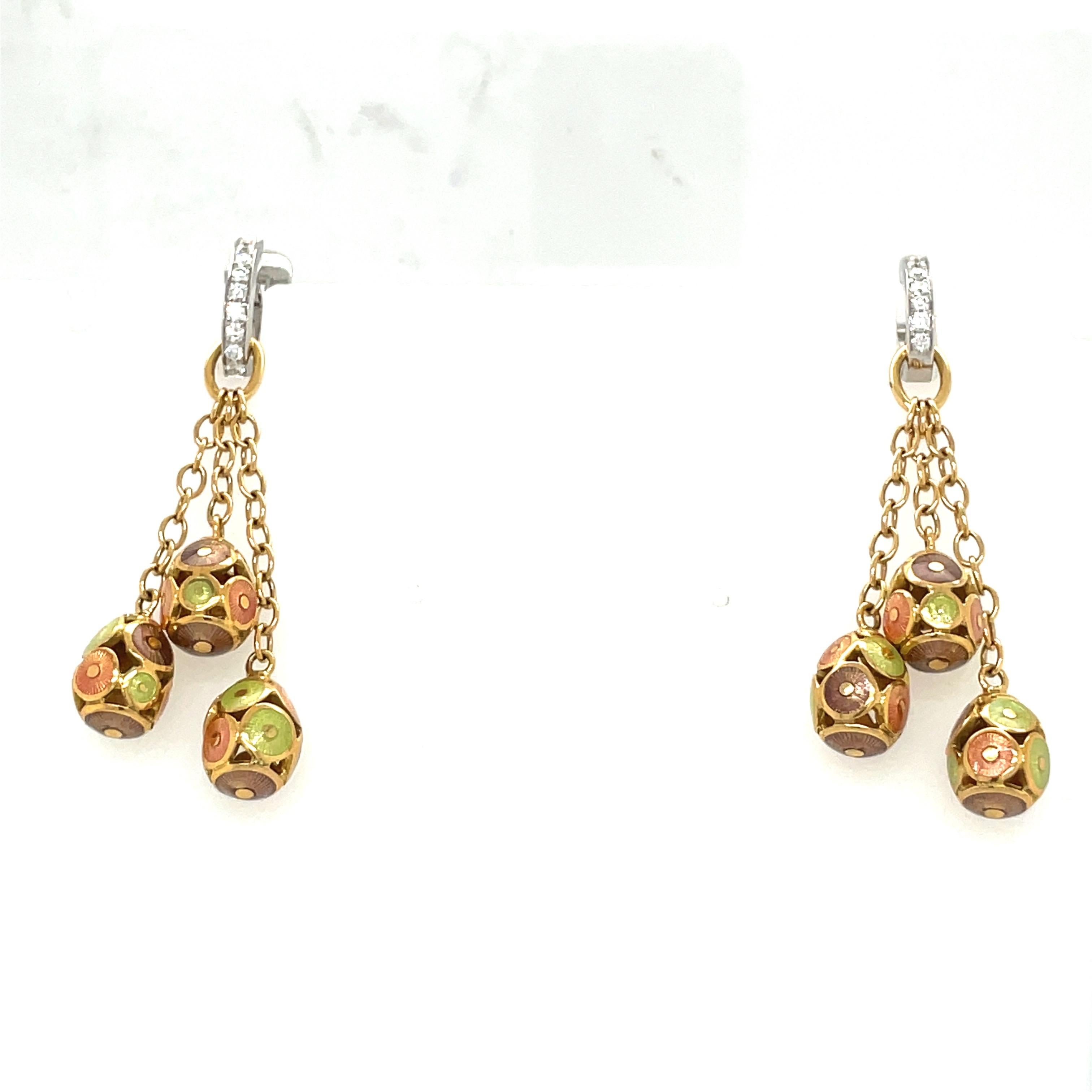 These modern 18 karat yellow Faberge earrings were crafted by Victor Mayer. Each earring features 3 hanging eggs, each with a circular pattern in peach, taupe,and mint green guilloche enamel. The enamel eggs are hanging from an 18 karat yellow gold