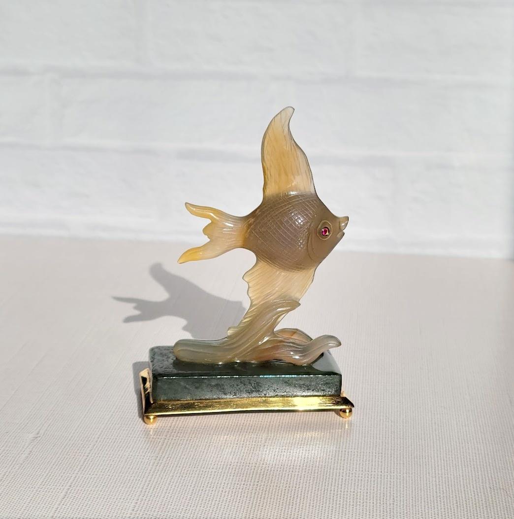 Fabergé Goldfisch-Skulptur - Ein Symbol für Glück und Eleganz

Wie ein schimmernder Traum, eingefangen in Stein, stellt diese exquisite Fabergé-Skulptur einen zarten Goldfisch dar, der meisterhaft aus leuchtendem Achat geschnitzt wurde. Seine mit