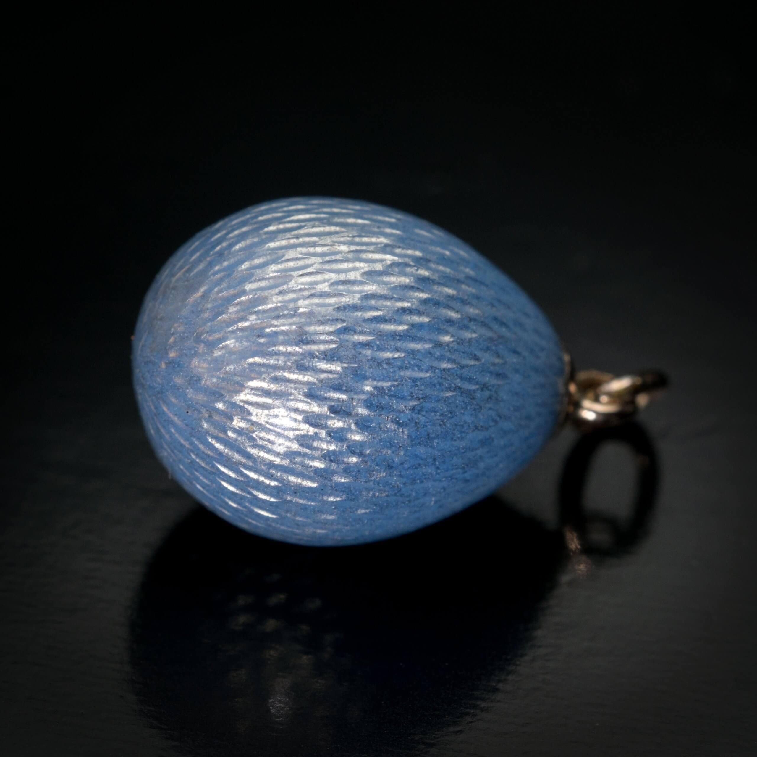 Made in Saint Petersburg between 1908 and 1917.  This FABERGE miniature egg is covered with a silver blue translucent guilloche enamel of a very fine quality.  The egg is marked with 56 zolotnik old Russian gold standard (14K) and initials ‘ФА’ for