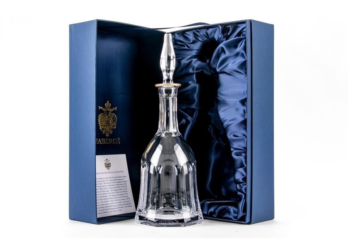 Faberge Aurora decanter from the Imperial Collection, style #426-20, clear cut crystal, bell-form with narrow neck becoming bulbous at body with octagonal base, gold painted rim, tear-form stopper. Etched signature as shown.
Dimensions: 11 1/2