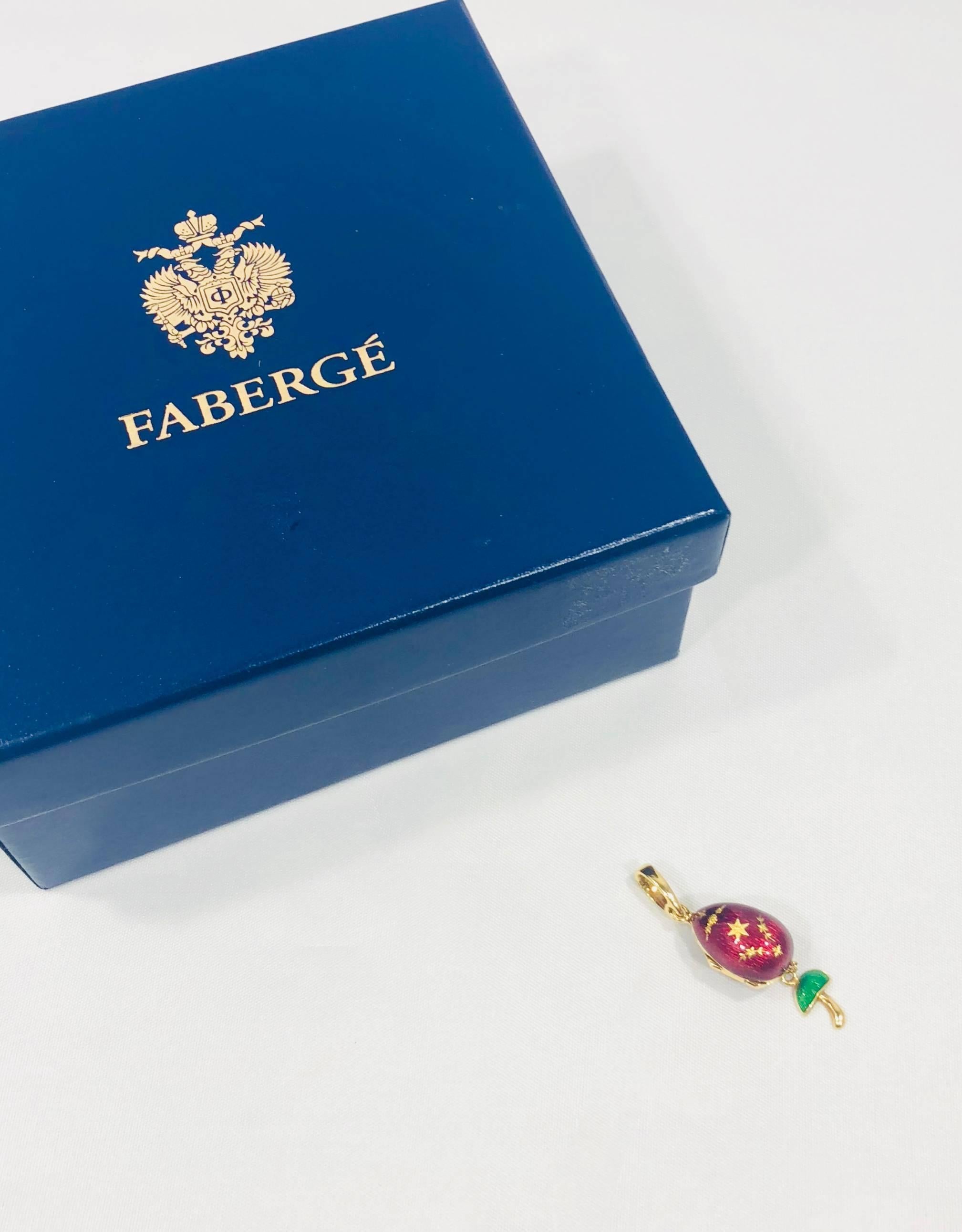 Faberge by Victor Mayer 18 karat gold and enamel egg locket pendant. This piece is created in 18 karat yellow gold and weighs 7.7 grams, 5 dwt. The piece is painted in a rich red enamel with an engraved gold design. The Egg locket opens to an