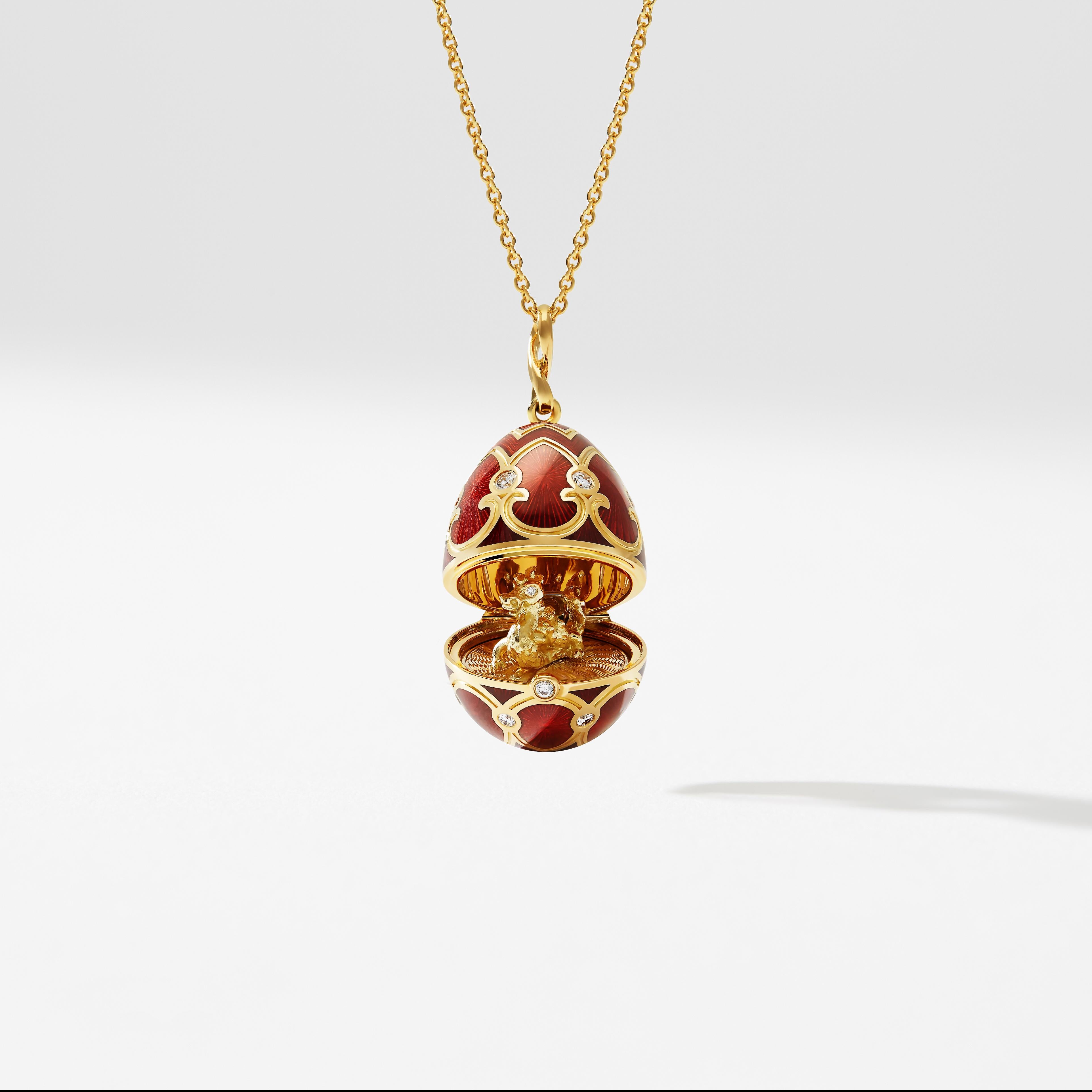 The Heritage Yellow Gold Diamond & Red Guilloché Enamel Year Of The Dragon Surprise Locket features red guilloché enamel and round white diamonds. The 22mm 18 karat yellow gold locket opens to reveal an 18 karat yellow gold dragon with diamond eyes,
