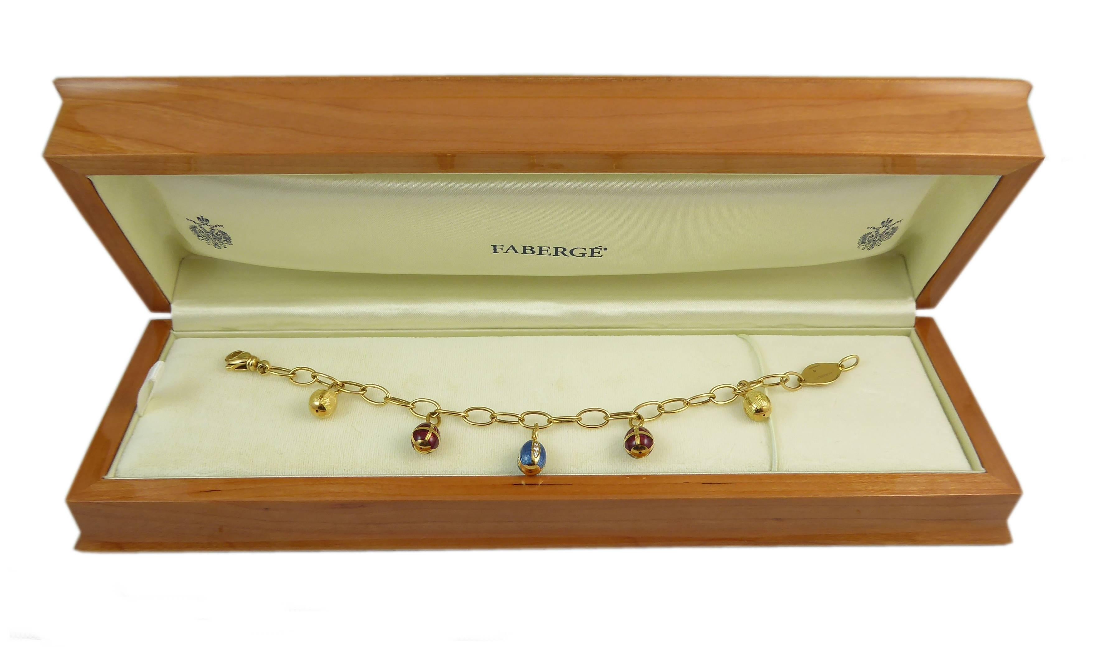 A delightful Easter egg bracelet by Faberge having five 18ct yellow gold egg charms evenly spaced along an 18ct yellow gold chain link bracelet.  

The centre egg is decorated with a rich turquoise blue guilloche enamel into which are set four