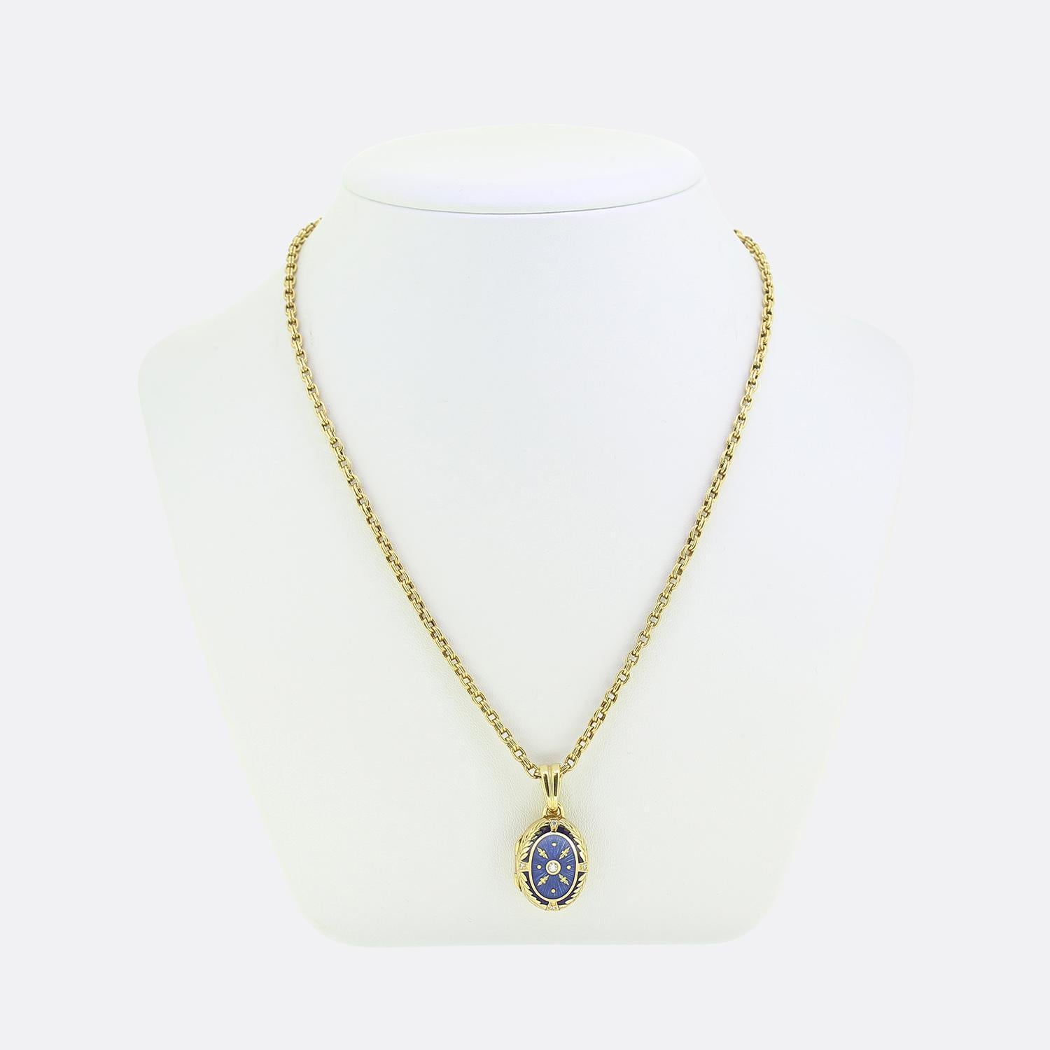 Ecco una collana a medaglione in oro giallo 18ct di Fabergé. Il medaglione presenta un diamante rotondo con taglio a brillante, circondato da intricati dettagli in oro su un ricco sfondo blu smaltato guilloché. Il design include piccoli accenti