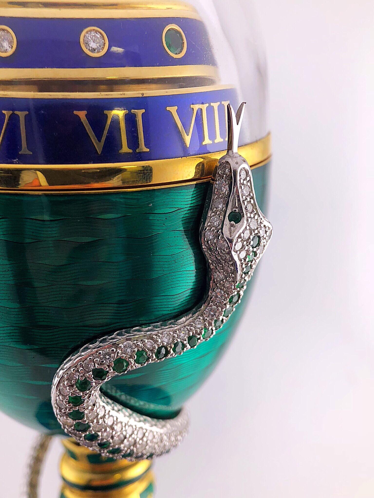 Attention to detail is a tradition still carried out today revealed once again in this extraordinary yet regal Serpent Clock Egg.
The green enamel egg sits atop a blue lapis base. The 18kt.white gold serpent, set with round diamonds and emeralds,