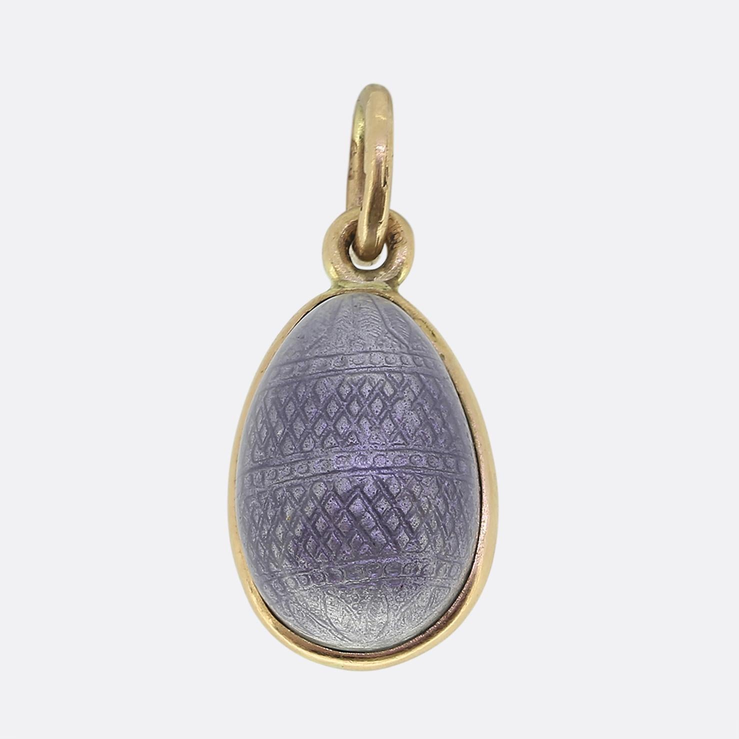 Here we have a delicate antique Fabergé egg pendant. This Russian piece has been crafted from 14ct yellow gold and features intricate floral detailing. The design showcases a bouquet of pink roses with green leaves, set against a textured, pale