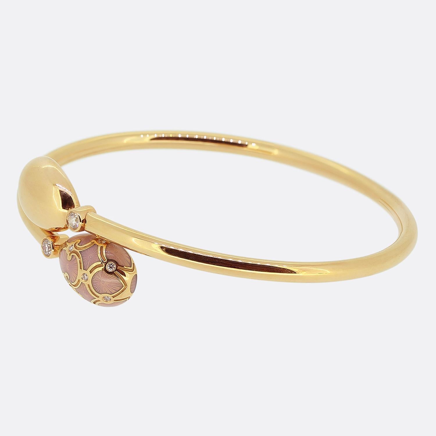 Here we have a distinctive bangle from the world renowned luxury jewellery house of Fabergé. Crafted from 18ct rose gold this piece features a sleek, polished band. At its focal point, two teardrop-shaped elements; one of which is adorned with