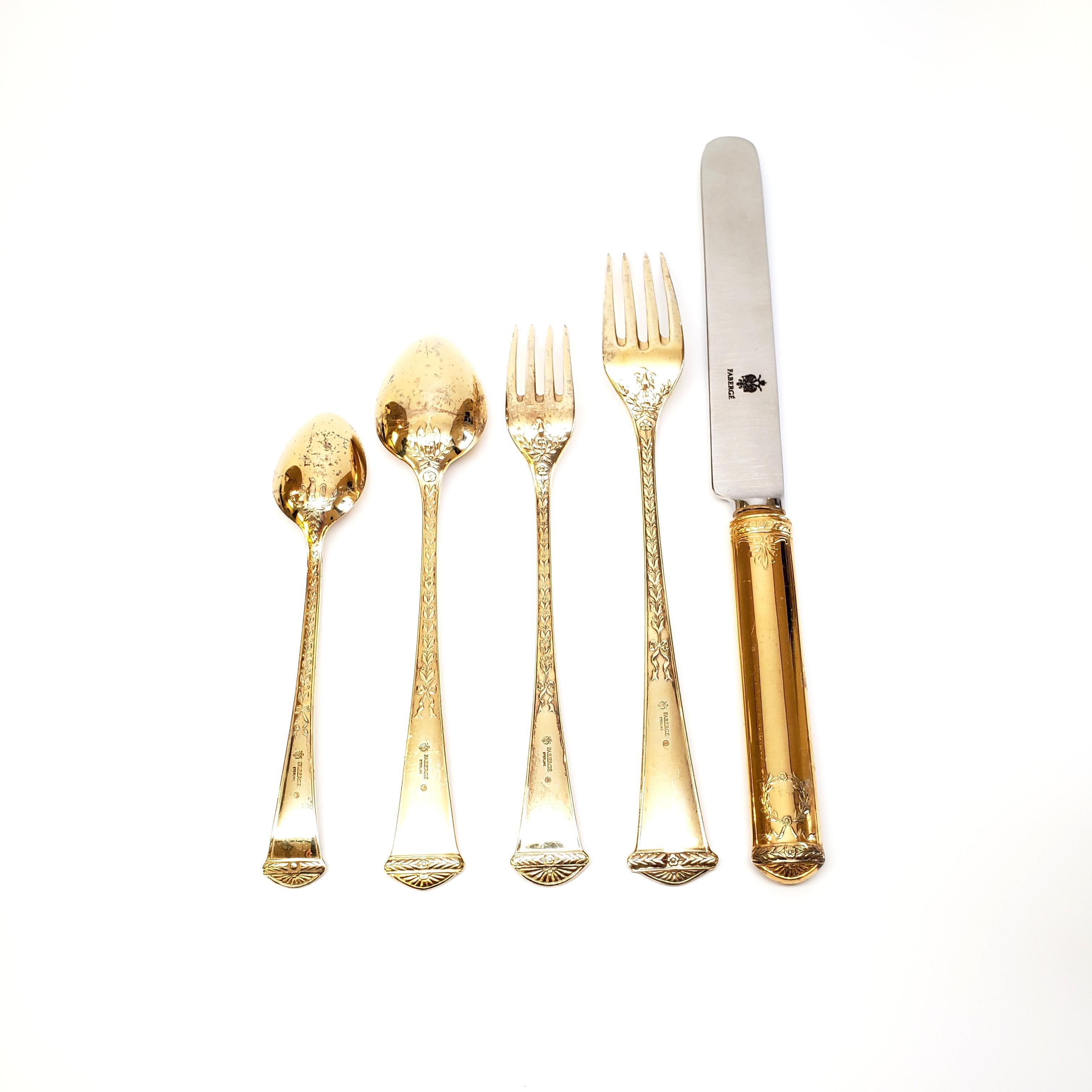 Gold vermeil over sterling silver 5pc place setting, by Faberge in the Imperial Court pattern. No monogram.

Faberge's now discontinued pattern features a wreath, an eagle and laurel leaves on both the front and back of each handle. This 5-piece