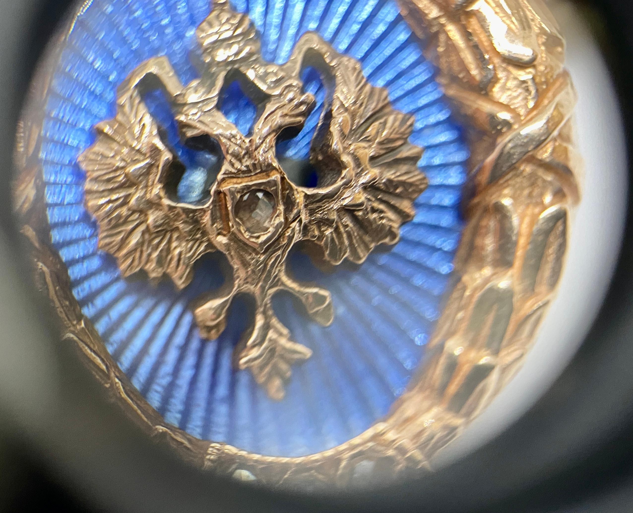 A superb pair of Imperial Russian cufflinks by Fabergé in rose gold featuring double-headed eagles on a blue guilloché enamel field. 

Made around the turn of the 20th Century, the cufflinks each have seven small, rose-cut diamonds on the faces, and