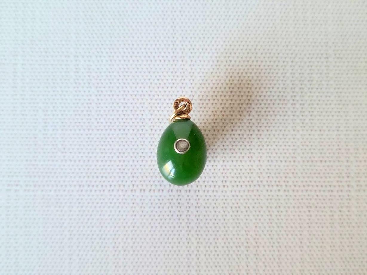 We are pleased to present another exceptional item from our collection—a charming miniature gold egg pendant crafted from genuine Russian nephrite and adorned with a faceted diamond element. This exquisite piece is one of Fabergé’s most prominent
