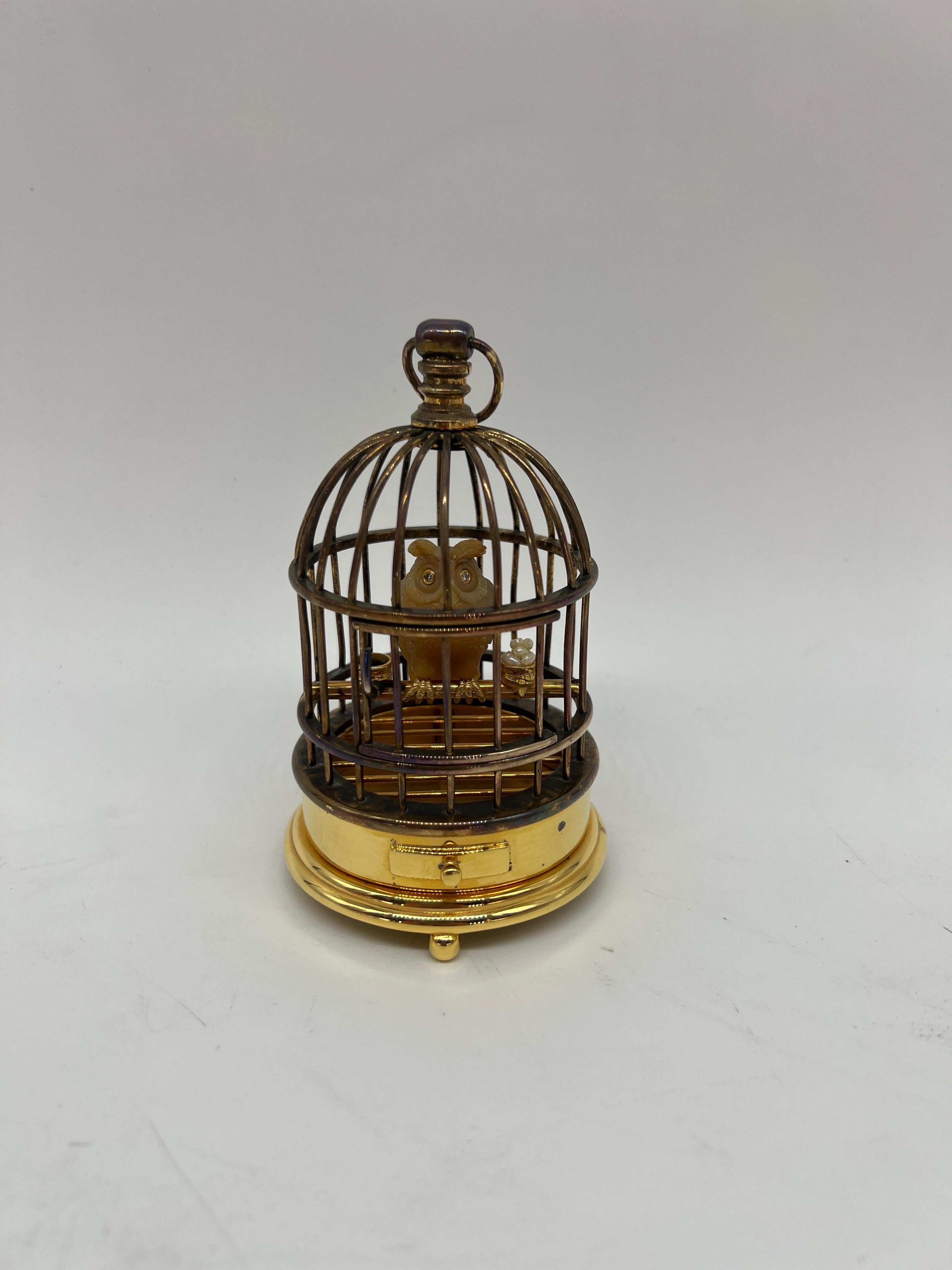 Faberge, 20th century. Jeweled and Silver-Gilt Model of an Owl in a Cage Diamond & Sterling.

This agate stone and realistically carved owl features diamond eyes and silver-gilt claws, in a silver-gilt cage with drawer and door. Flanking the owl is