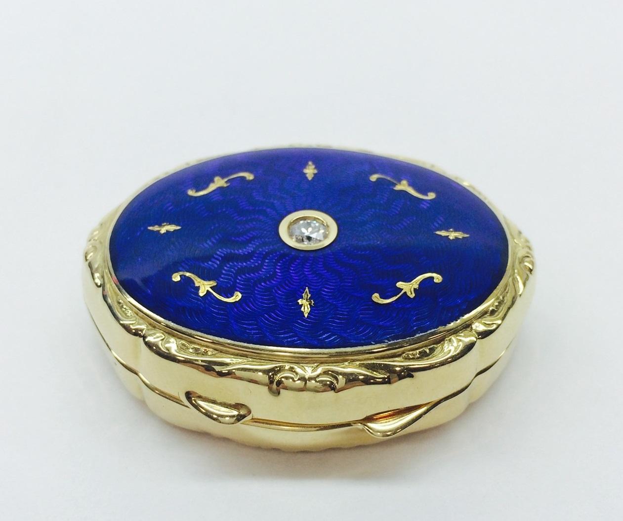 One Fabergé 18-karat yellow gold limited-edition French-guilloché blue enamel and diamond oval shaped pillbox. The box measures approximately 4.5 cm L x 3.5 cm W x 1.0 cm D and has a hinged cobalt-blue enameled top embellished with 24-Karat handmade