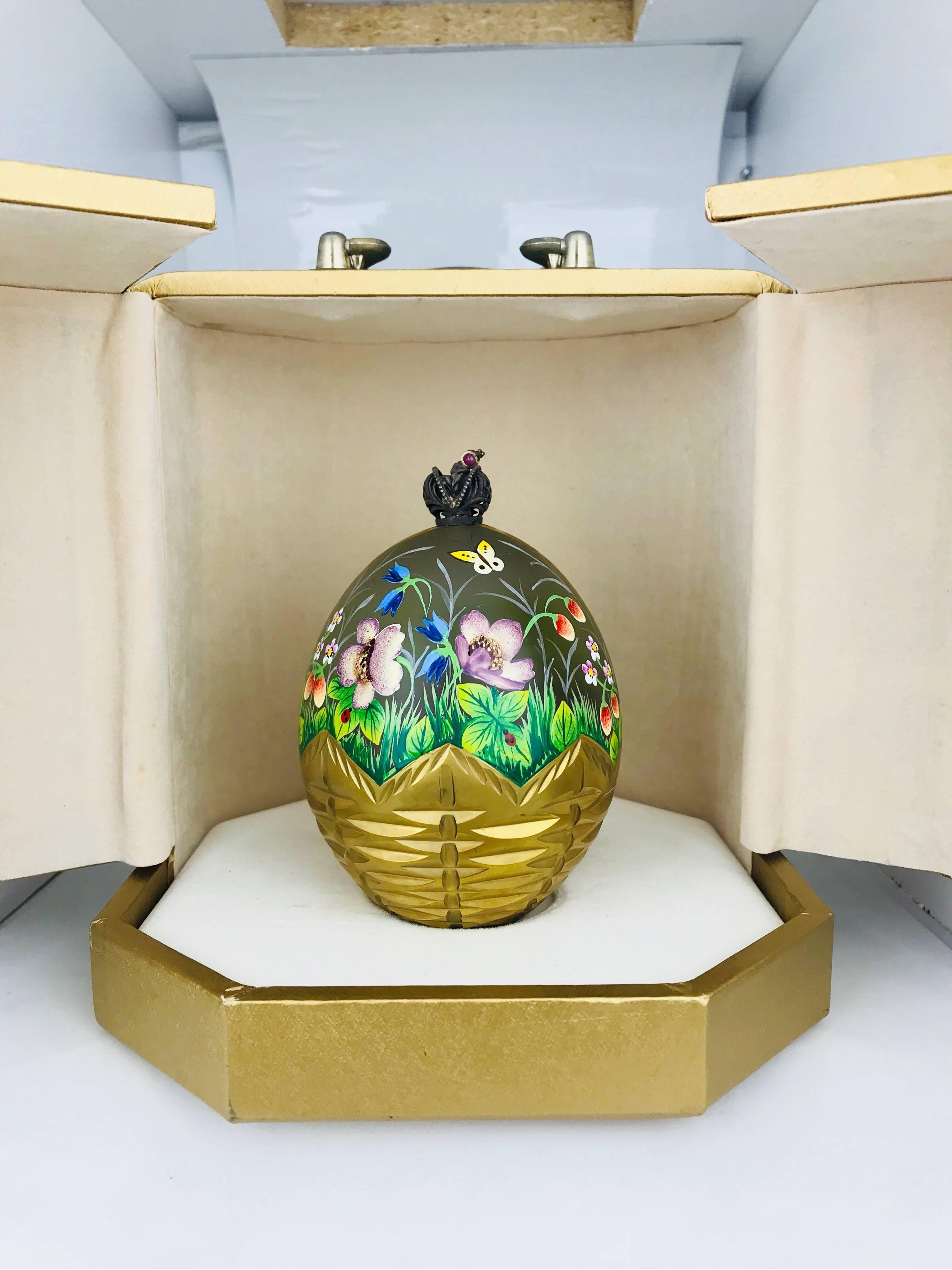 Faberge Limited Edition, Summer Egg.  Hand painted and gilded in 23 carat gold  with pictures of flowers and butterfly's in a meadow.  This famous limited edition is number 220 out of 750 and comes with original Box and Papers.  
The scene is set in