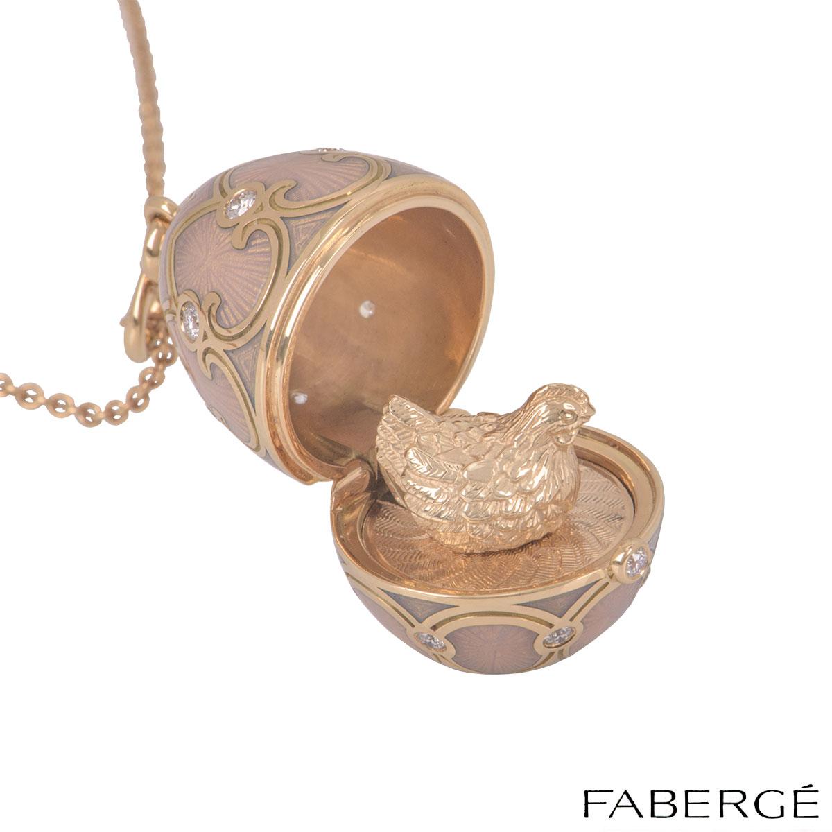 An 18k rose gold, pink guilloché enamel and diamonds egg pendant by Faberge from the Heritage Collection. The pendant is set in rose gold featuring opalescent pink guilloché enamel with round brilliant cut diamonds placed evenly on top and bottom