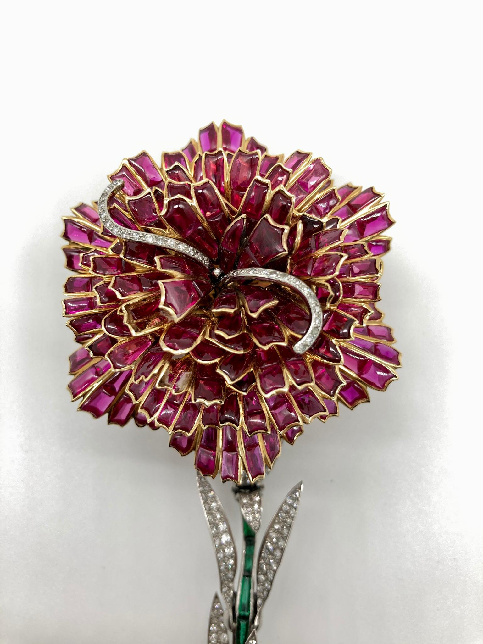 Élégante broche fleur en or blanc de Fabergé, ornée de rubis, d'émeraudes et de diamants. France, vers les années 1990.
(