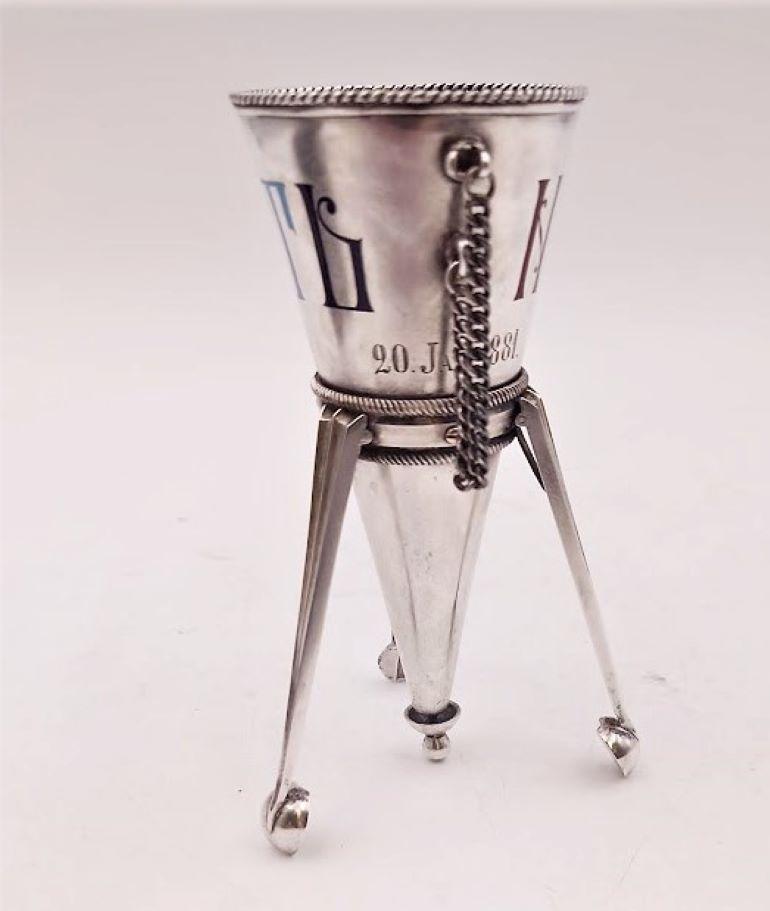 Possibly Faberge, 1881 silver posey holder with enameled Cyrillic inscriptions, standing on 3 feet, with chain holder. 

It measures 4 1/2'' in height by 2 3/4'' in width by 2 3/4'' in depth and bears hallmarks as shown. 

 