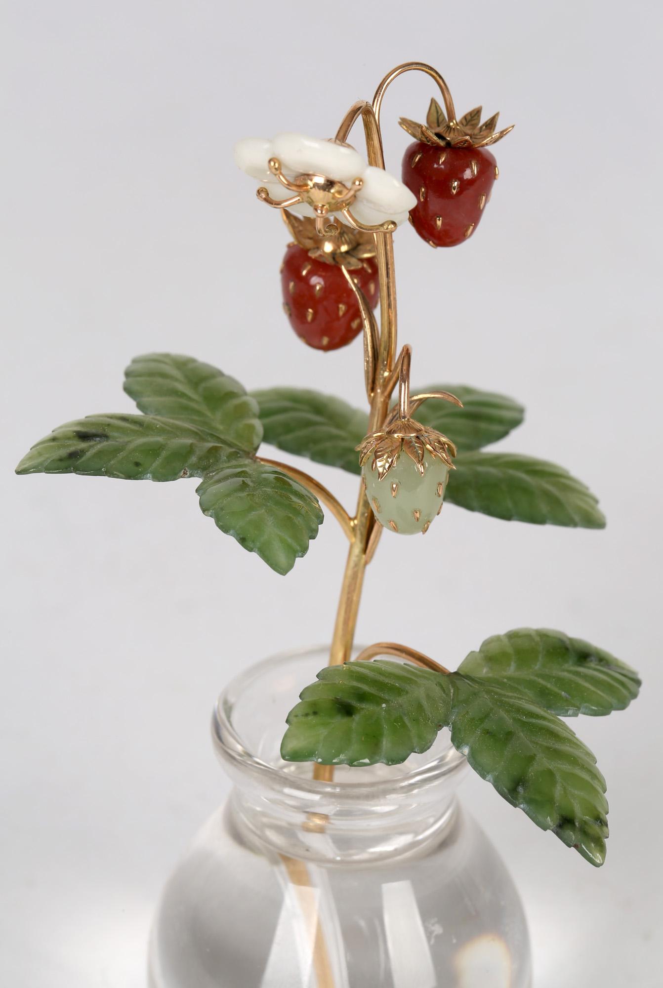 An exquisite Russian gold stemmed wild strawberry mounted in a clear crystal vase in the style of renowned Russian jeweller Peter Karl Fabergé (1864-1920) and believed to date from the early to mid 20th century. The stem is mounted with three leaves