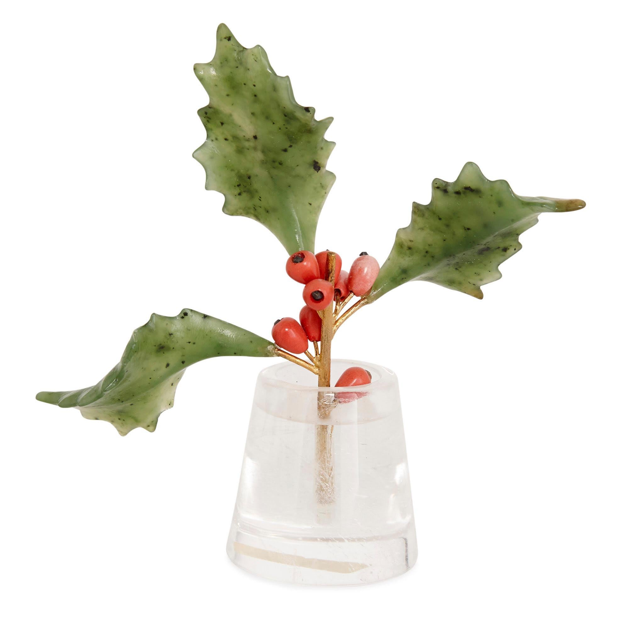 This model of a spray of holly is designed about the artistic conceit of the trompe l’oeil, or that which fools the eye. The stem of the spray rests in a rock crystal vase, the idea of which is to imitate a glass container filled with transparent