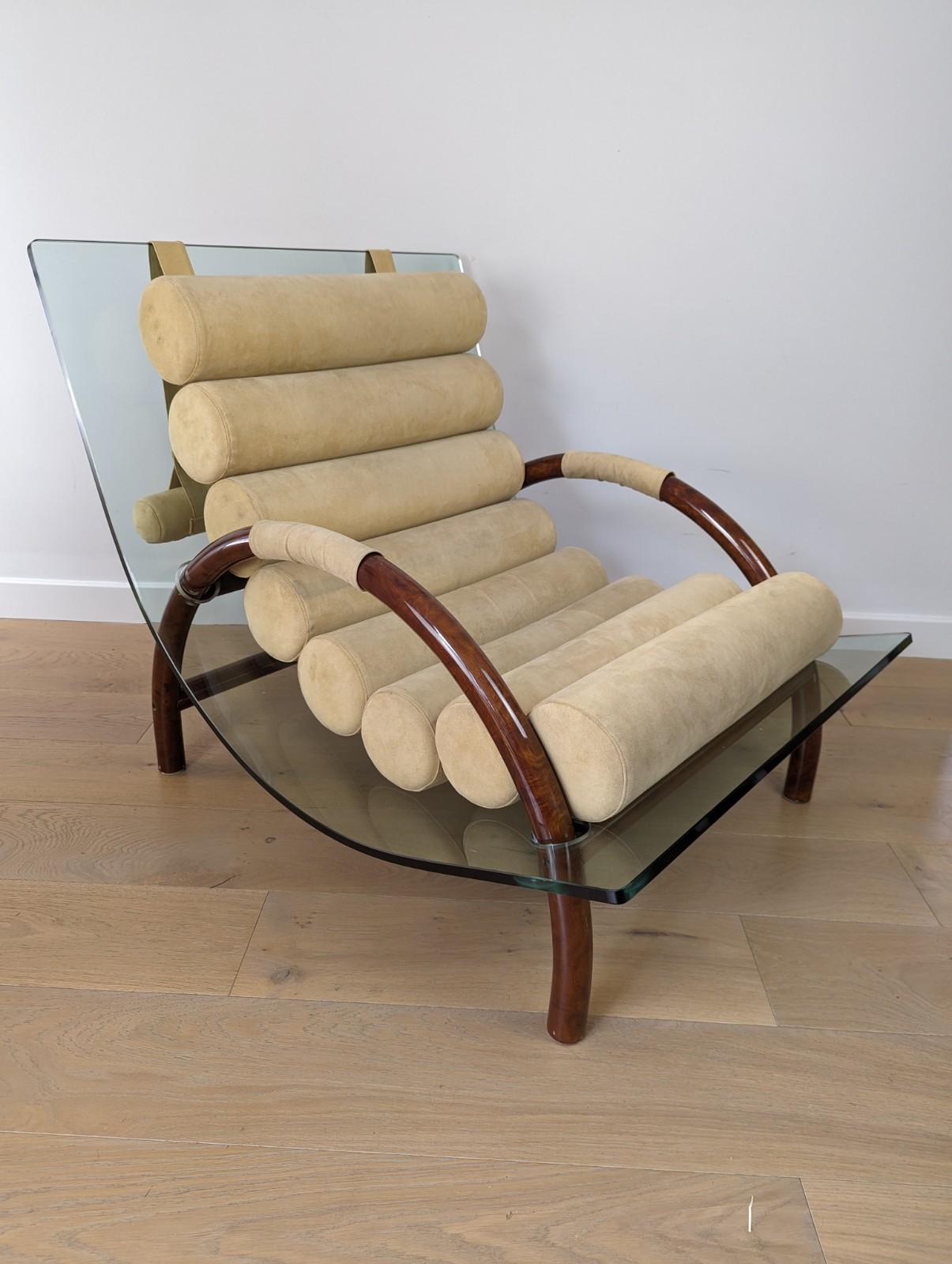 A very unusual curved glass armchair with loose cylindrical cushions. The curved glass base sits on a burled walnut tubular base which has half moon armrests.

The chair is very much in the style of Fabio Lenci and is a real statement. The cushions