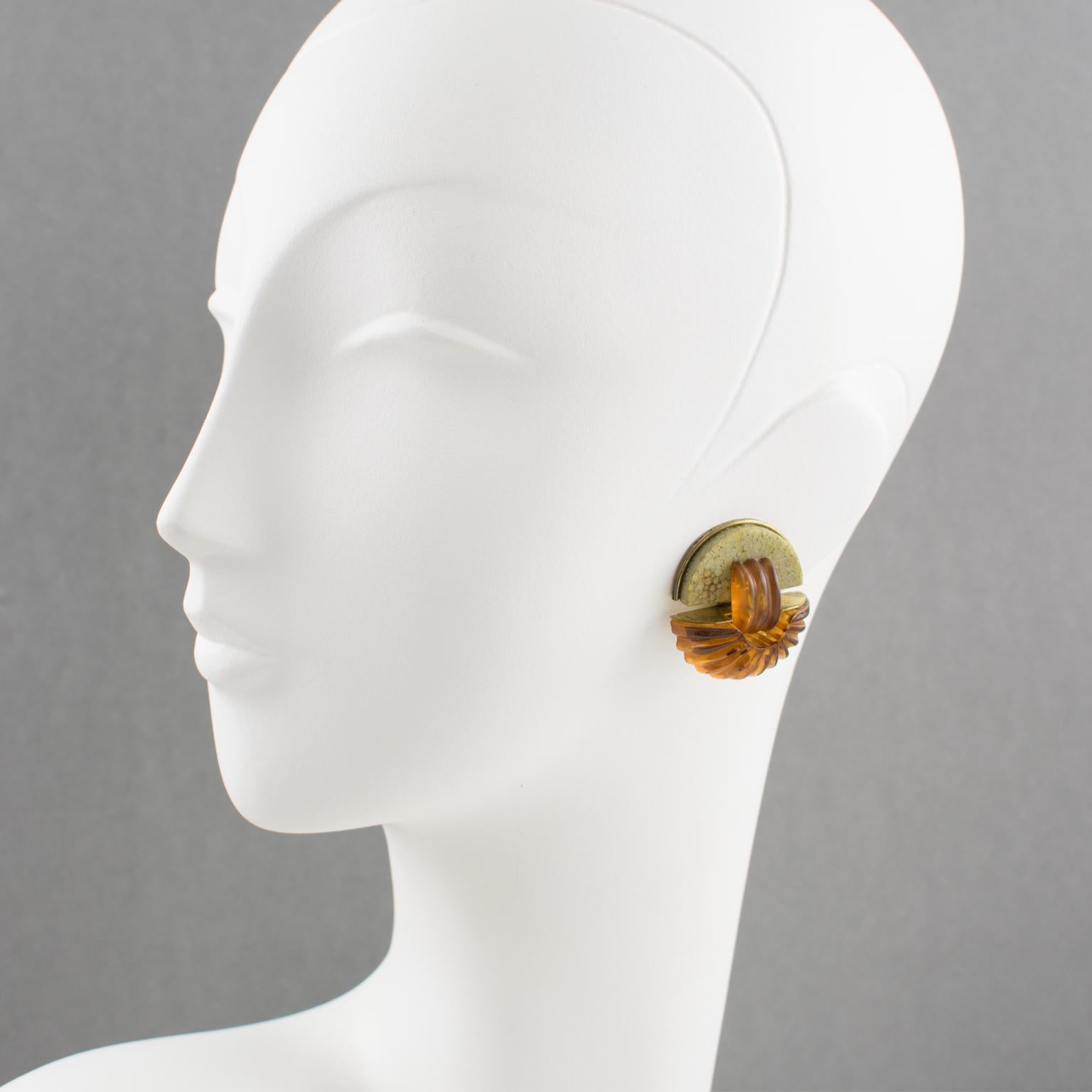 Elegant Fabrice Paris signed clip-on earrings. Featuring Art Deco revival inspired geometric design. Gilt brass framing topped with natural shagreen (stingray skin) and ornate with carved resin elements in translucent apple juice and amber color.