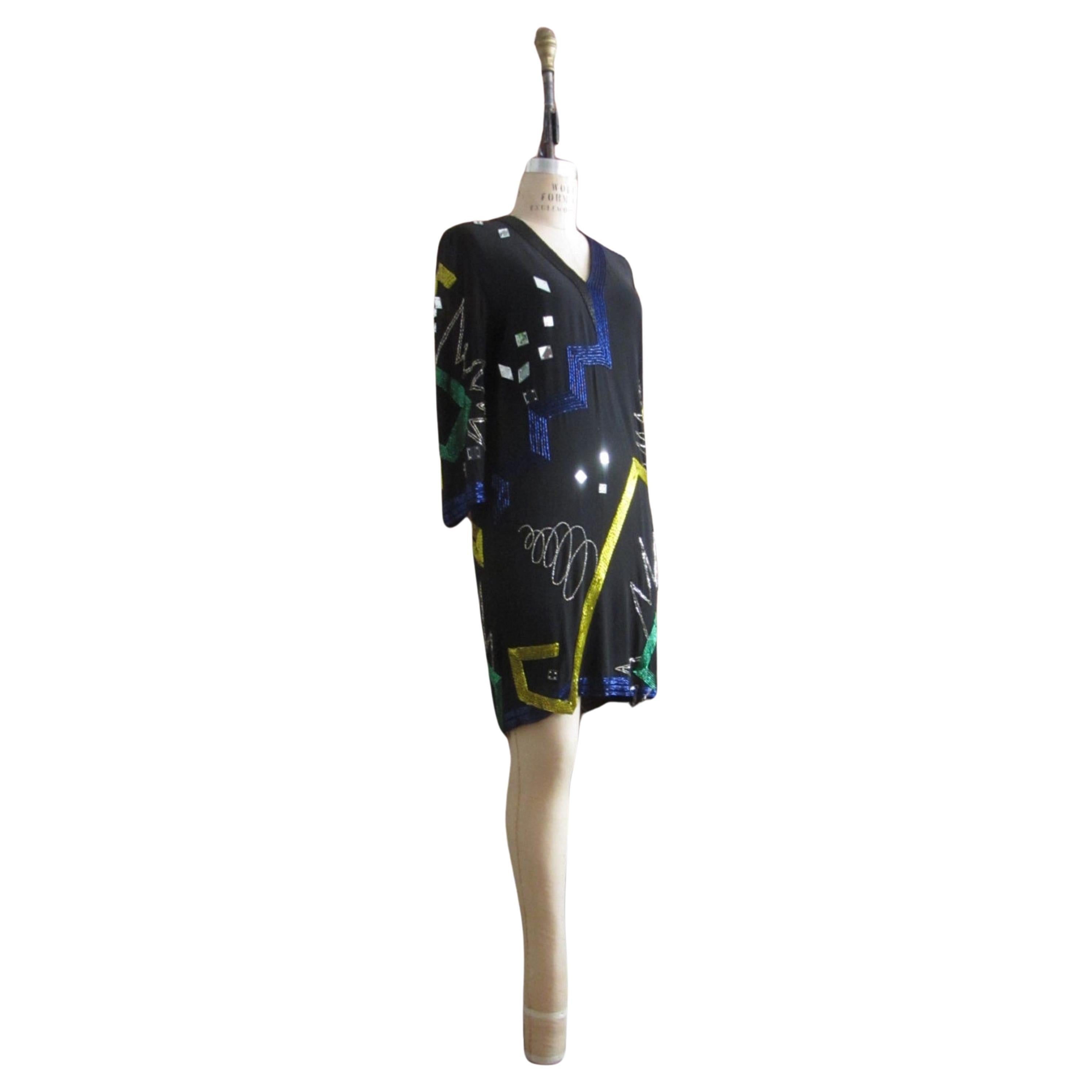 Amazing black silk chiffon pop art beaded dress by Fabrice Simon.
hand sewn multi colored abstract shapes
green, blue, silver, gold seed and bugle beads
squares and prism shaped lucite mirrors
v neck collar
sheer 3/4 length sleeves
loose fitting