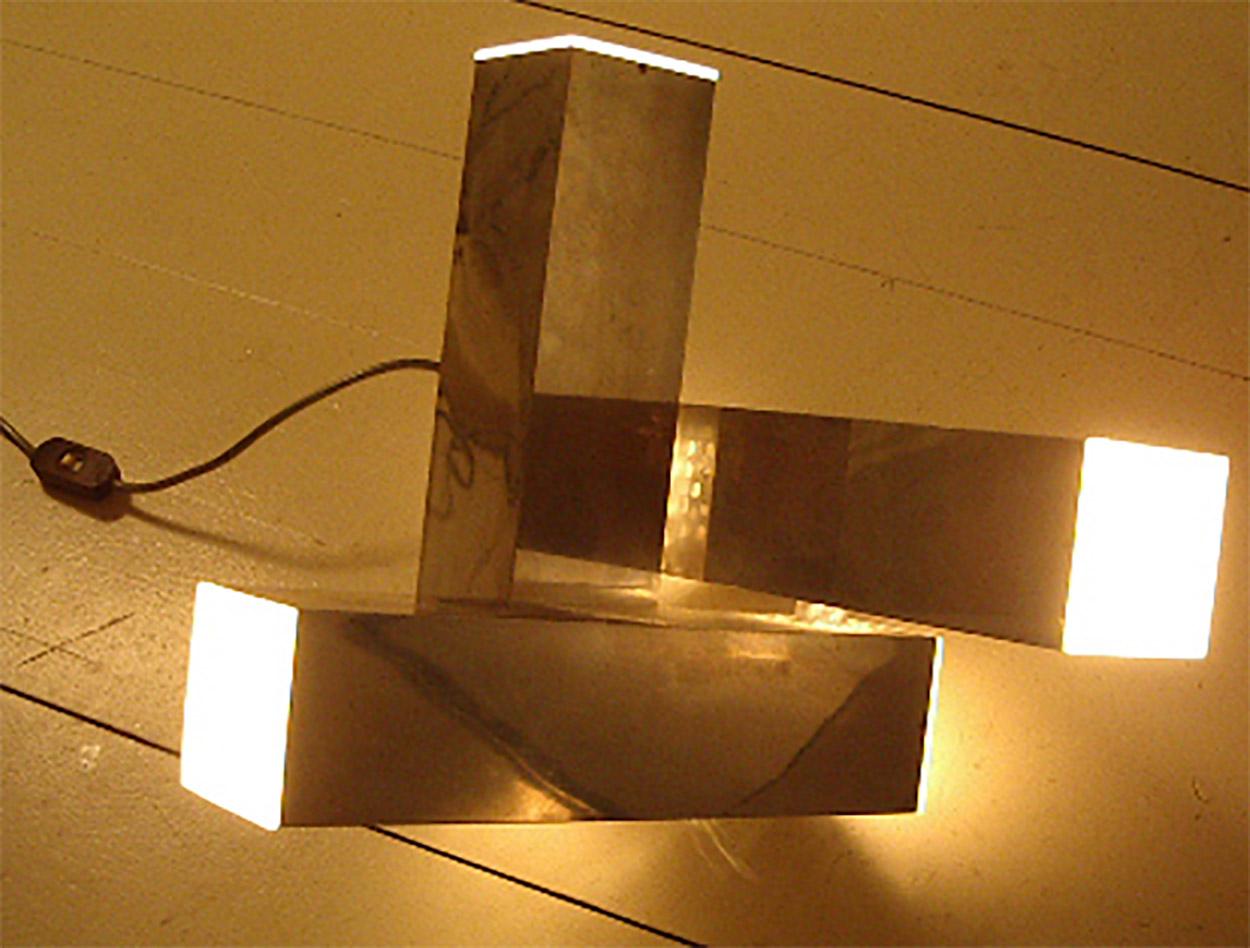 Ascissa steel table lamp manufactured by New Lamp, designed by Gianfranco Fini e Fabrizio Cocca in 1970. The final satin metacrilato spreads the light.
The three parallelepipeds are positioned along the orthogonal lines of space.