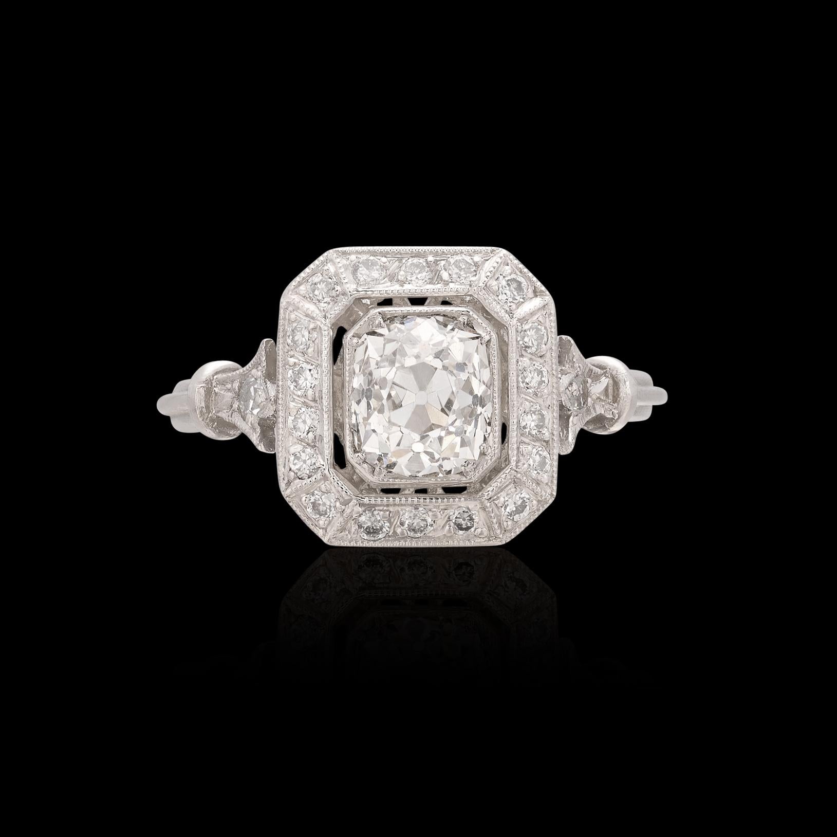 An old world antique diamond perfectly set in an Art Deco inspired platinum ring. A truly special 1.02 carat Old Mine Cut diamond is the centerpiece of this beauty that features a halo of fine round cut stones and one perfectly set accent stone on