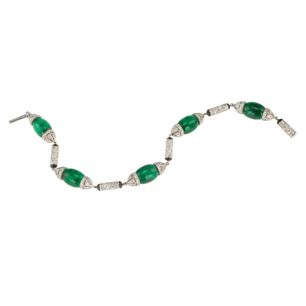 Fabulous Cartier style 18k white gold, emerald, diamond and onyx bracelet. Designed as a series of emerald polished elongated cabochons, mounted in white gold and set with onyx and accented with diamonds.

Length: 18cm
Width: 1cm
Weight: 17.5g
