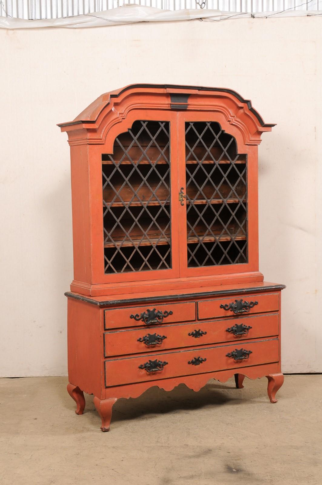 A Swedish Rococo painted wood display and storage cabinet from the 18th century. This antique cabinet from Sweden, which stands just over 7 feet in height, features a gracefully arched pediment bonnet comprised of layers of trim molding, crowning