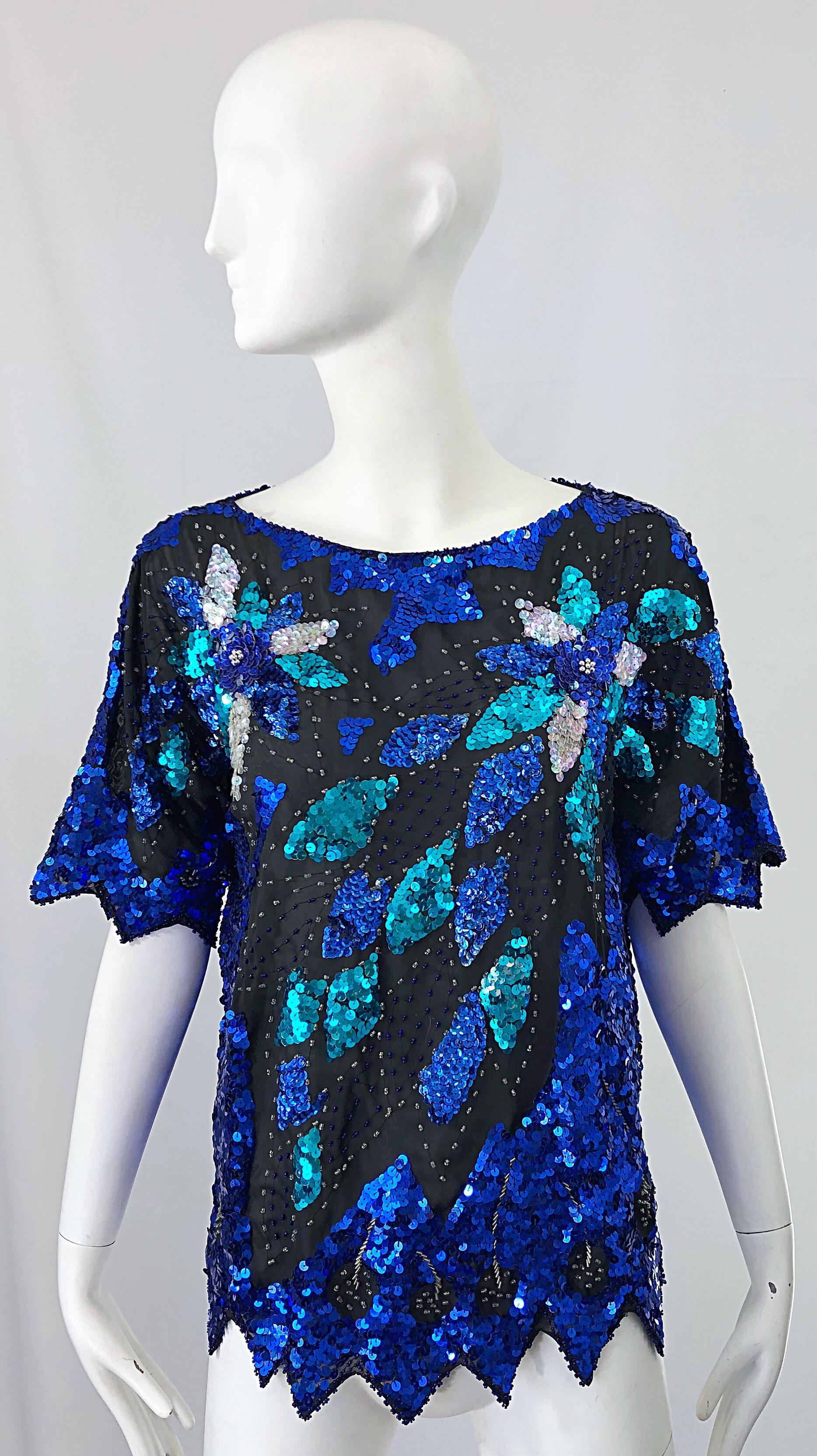 Fabulous vintage 1980s blue, turquoise and silver sequin and beaded larger size silk blouse ! Features black silk with thousands of vibrant blue, turquoise sequins and silver sequins and beads throughout. Scalloped hem and sleeves. Simply slips over