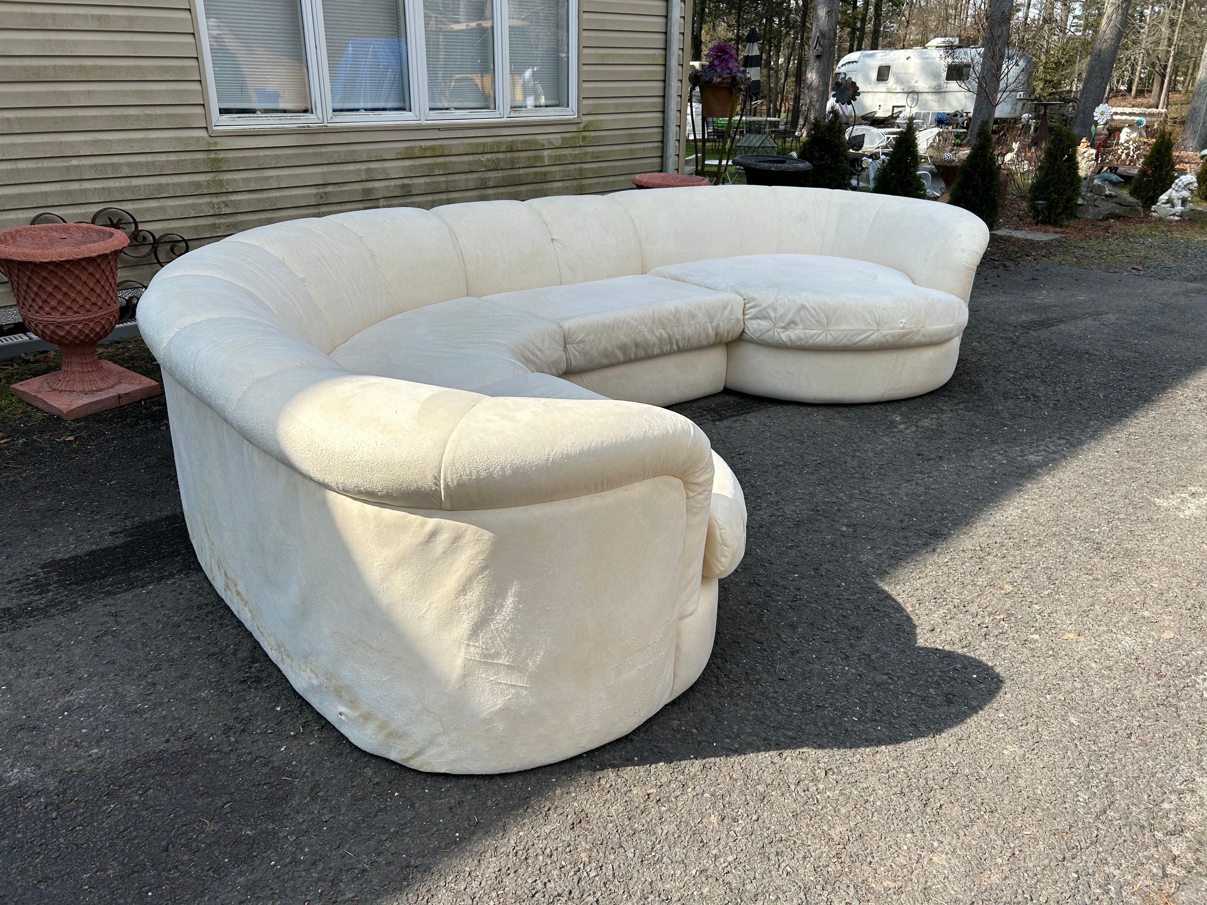 Wonderful 4 piece Milo Baughman style curved sectional sofa.  We love the oversized channeled back and arms along with the circular end pieces.  This sofa will need to be reupholstered as the original ultra-suede is well worn.  It measures 29