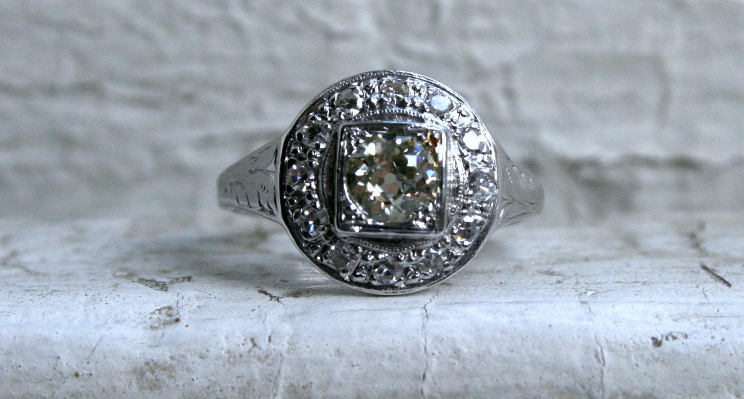 This Fabulous Antique Diamond Cluster Engagement Ring is just amazing! The design is basically the antique version of a Halo Ring - with a center diamond surrounded by more diamonds and finished with some wonderful hand engraving and beaded edges!