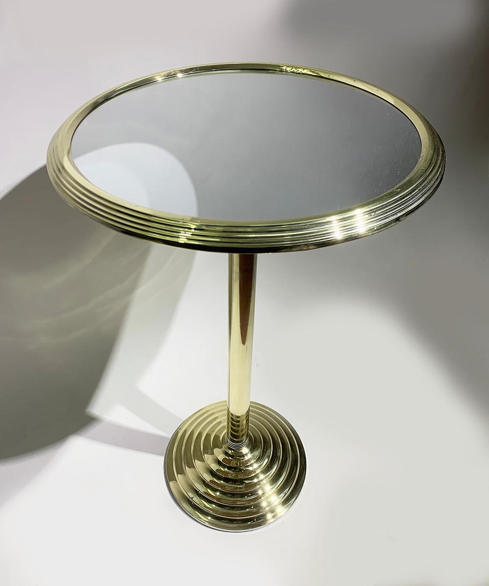 A beautiful round Art Deco pedestal side table, with mirrored top and brass pedestal.
