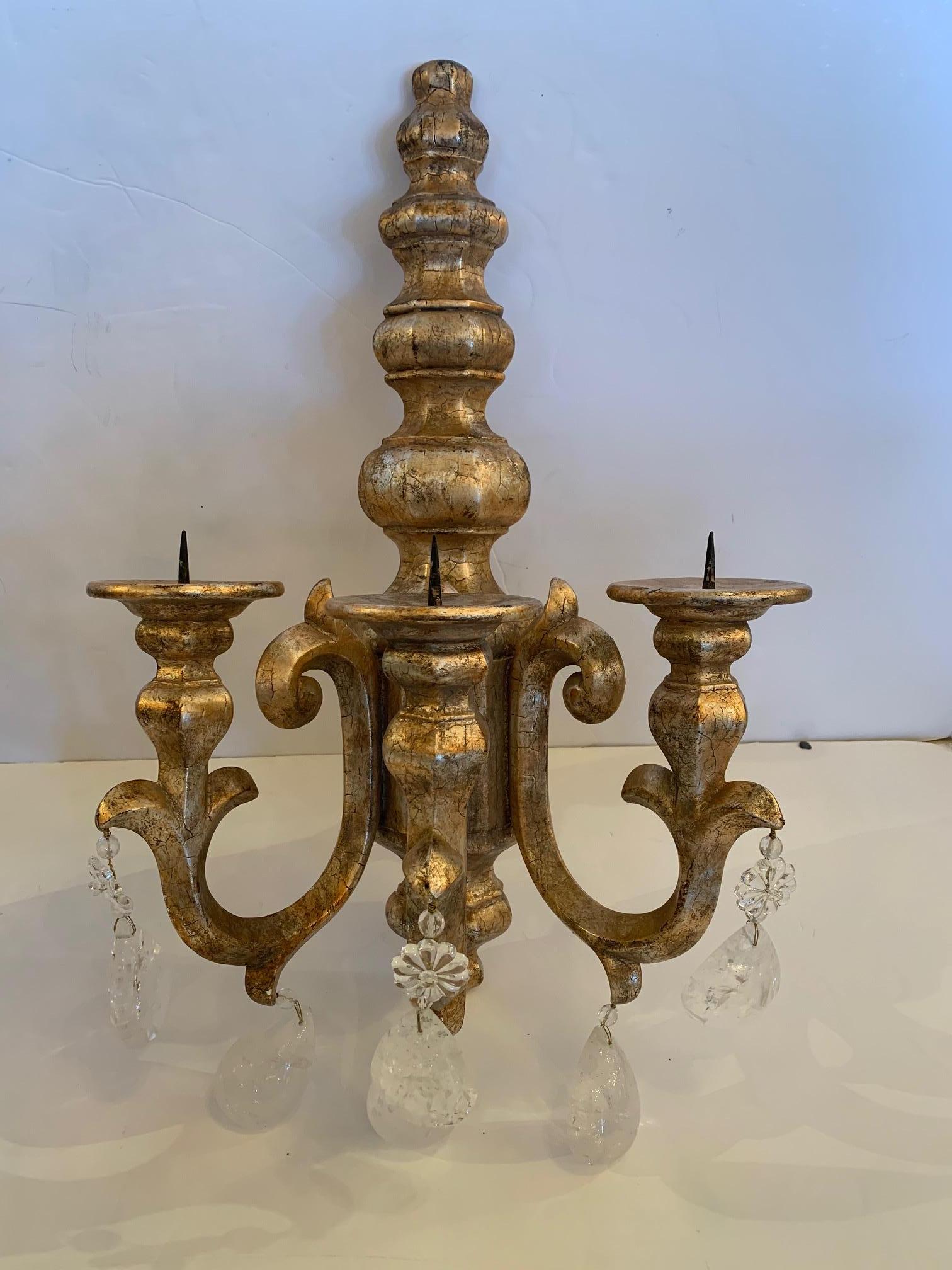 Impressive glamorous pair of chunky giltwood candle sconces dripping with large rock crystals.
Matching grand chandelier is also available. Both are from a top East Coast designers personal collection.
No markings but designer believes maker is