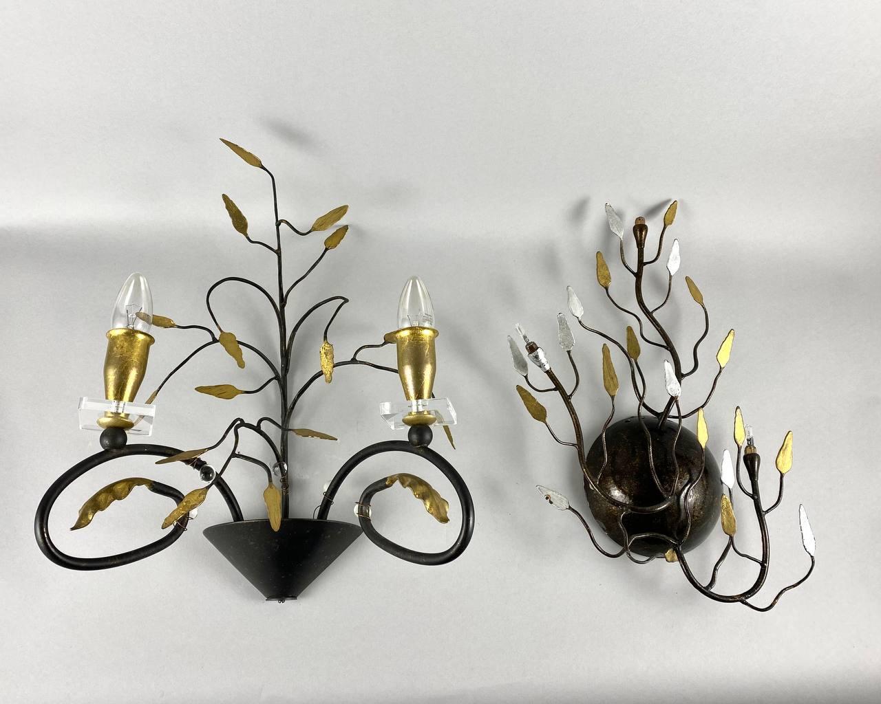 Fabulous pair of vintage 2-arm E14 and 3-arm halogen wall lamps with wrought iron volute fittings.

Italy, circa 1980s.

Glass transparent cups under the lamps. Armature color: black-brown with golden leaves.

Wrought iron frame handcrafted by