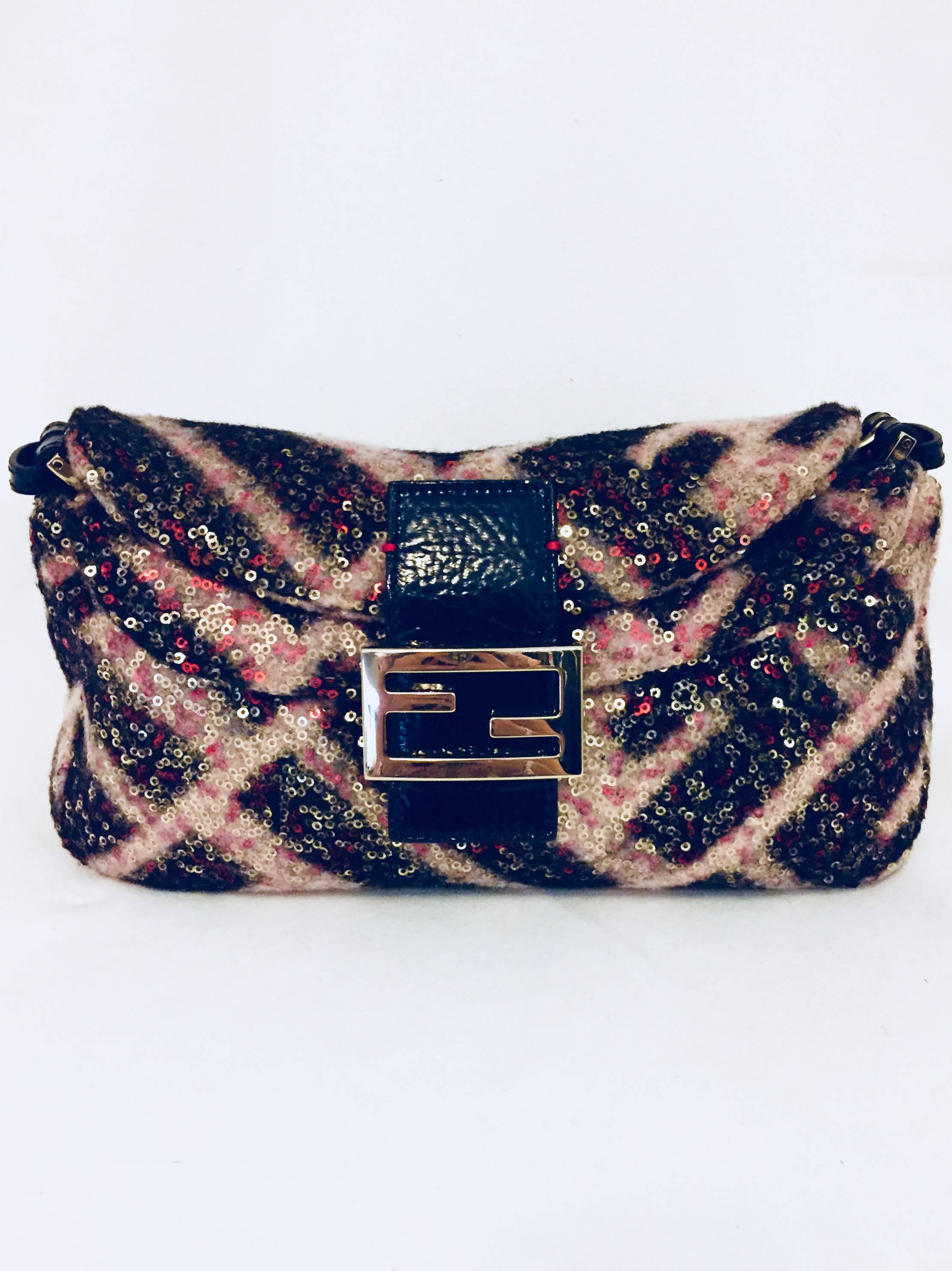 This Fendi multi color wool baguette bag covered in gold tone and red sequins on the exterior can be worn daytime or nighttime.  The two flaps fully open and the top flap contains the iconic double F logo with hidden magnet snap closure.  The