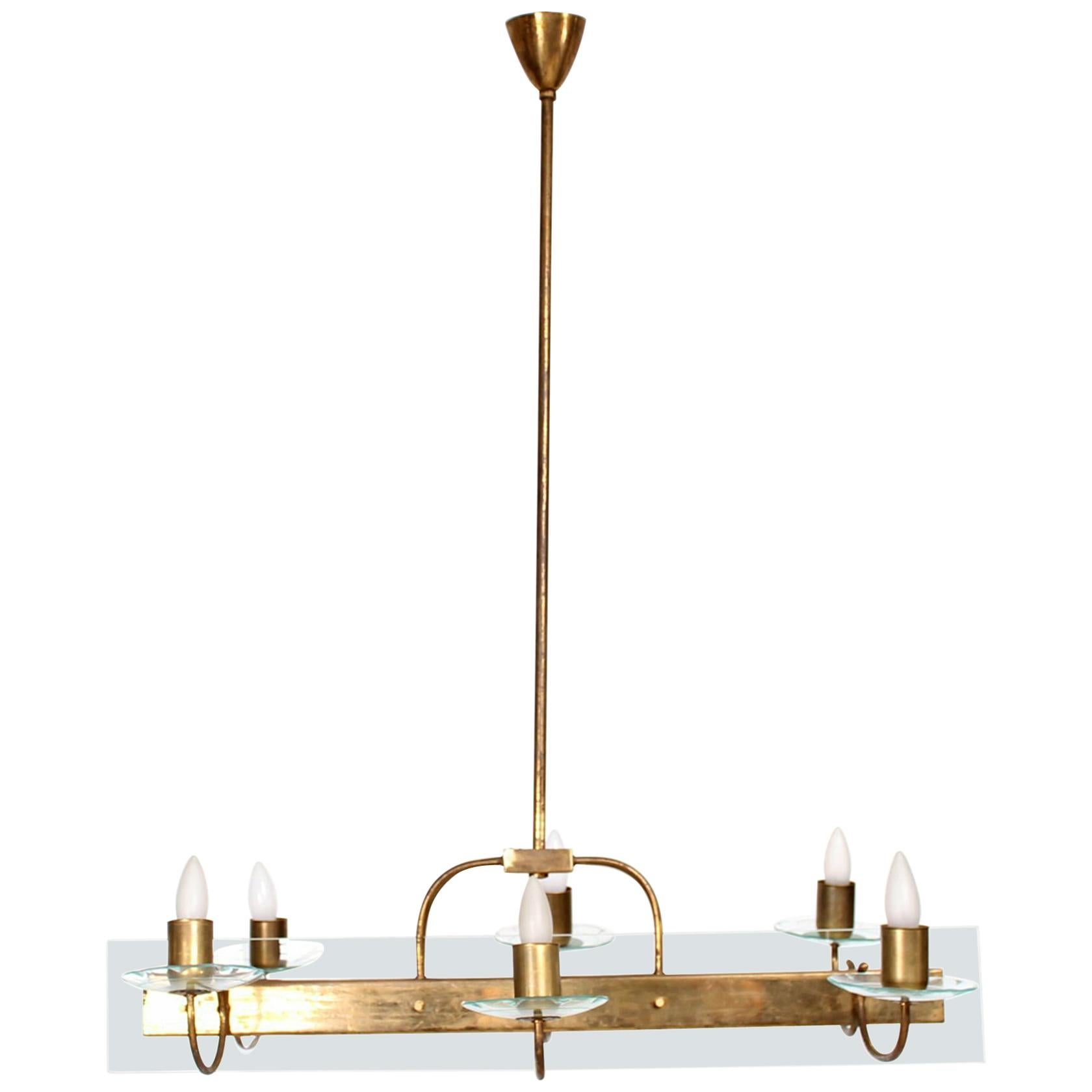 Fabulous Floating Six Arm Italian Chandelier attributed to Fontana Arte.
Midcentury Modern elegance 1950s Italy.
No maker remains.
Bold Brass Construction with Pristine Glass Accents (cut by hand).
Three arms per side. Requiring six E-14 bulbs (not