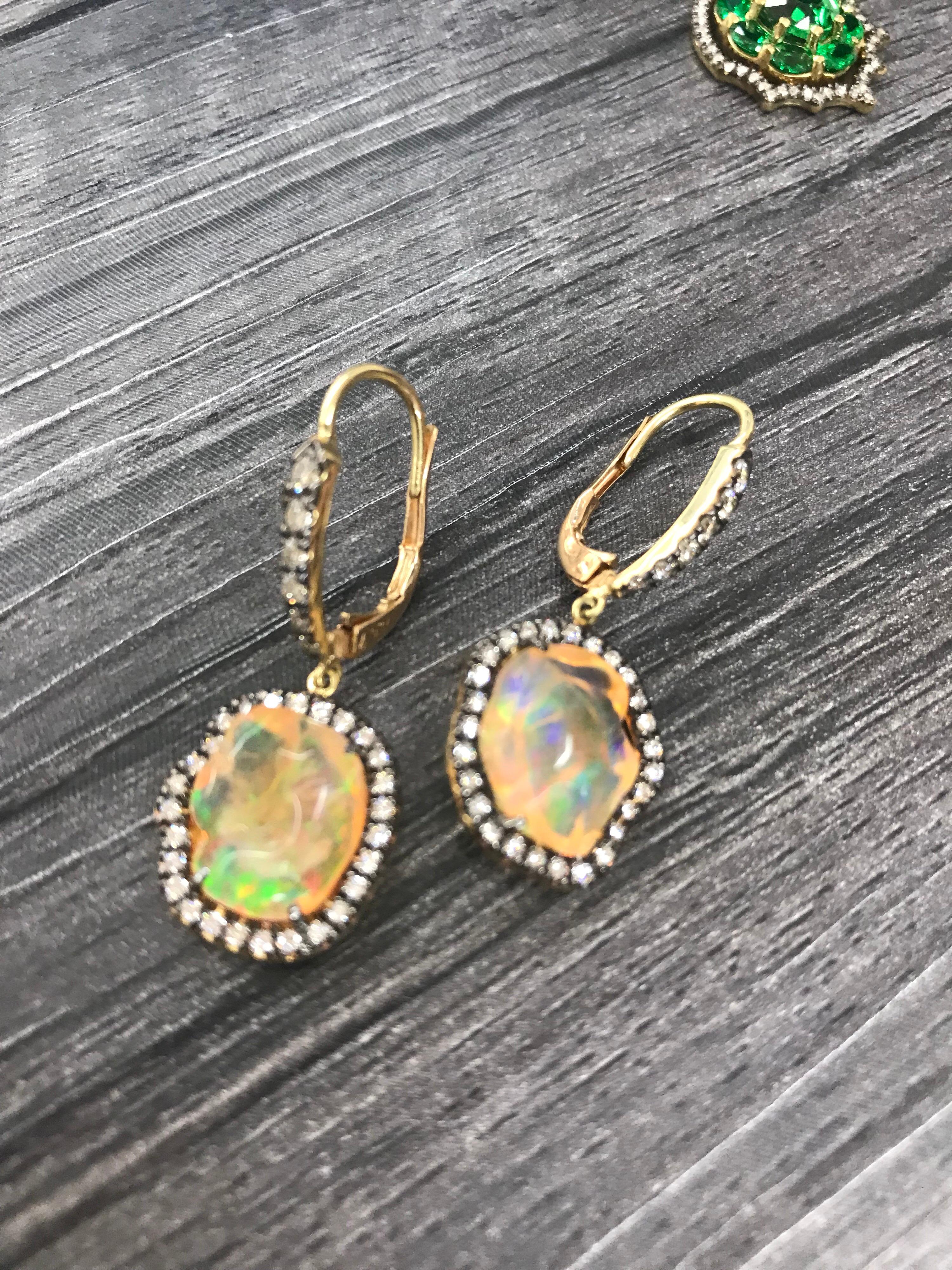 Die Freiform-Ohrringe aus mexikanischem Opal, umgeben von farblosen Diamanten in 18 K Gelbgold, mit Diamanten besetzt. Die intensiven Farben dieser Edelsteine haben ihnen den Spitznamen Feueropal eingebracht. Diese bemerkenswerten Steine zeigen ein